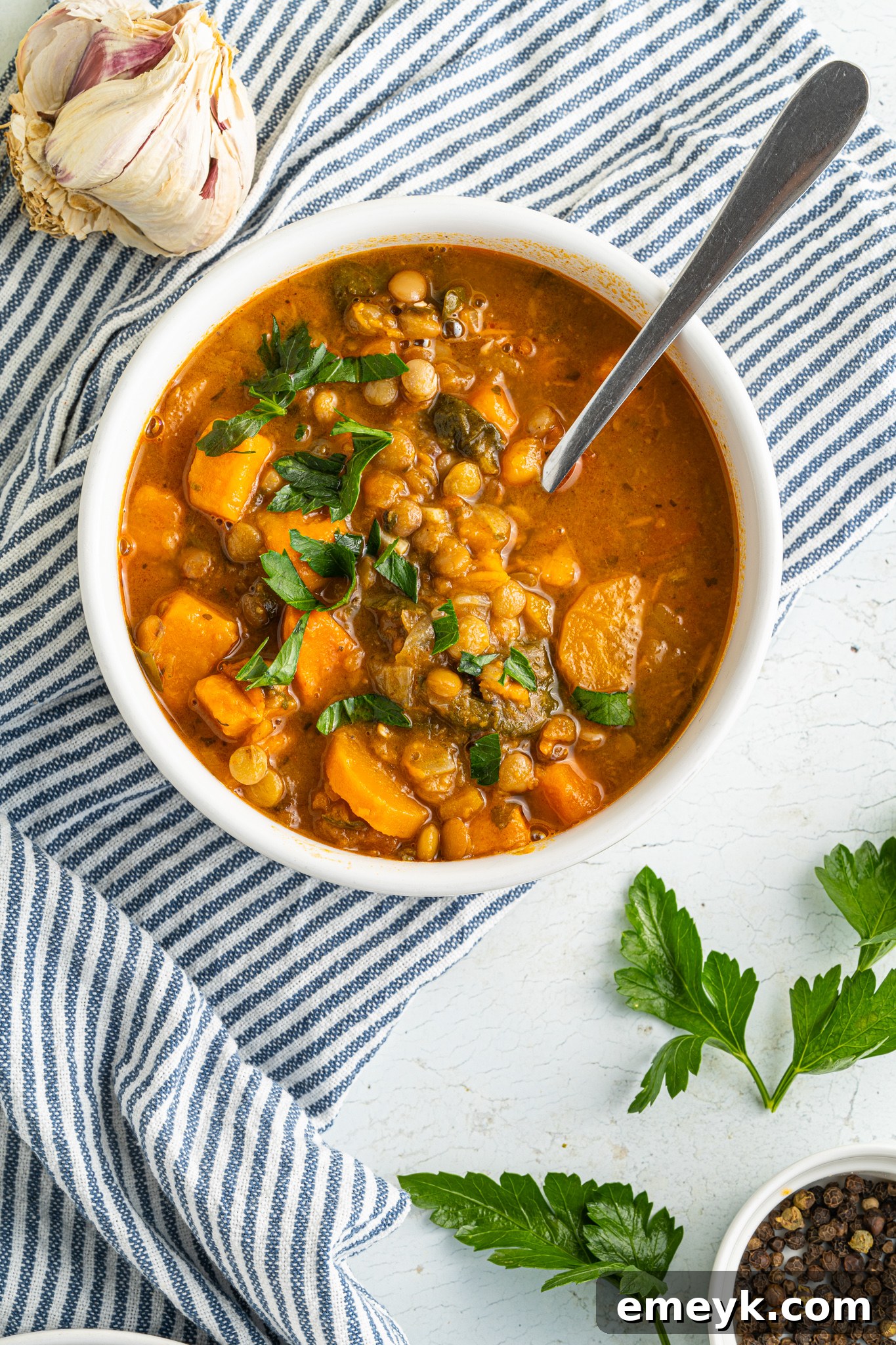 A bowl of Sweet Potato Lentil Soup garnished with fresh parsley, highlighting its vibrant and wholesome appeal.