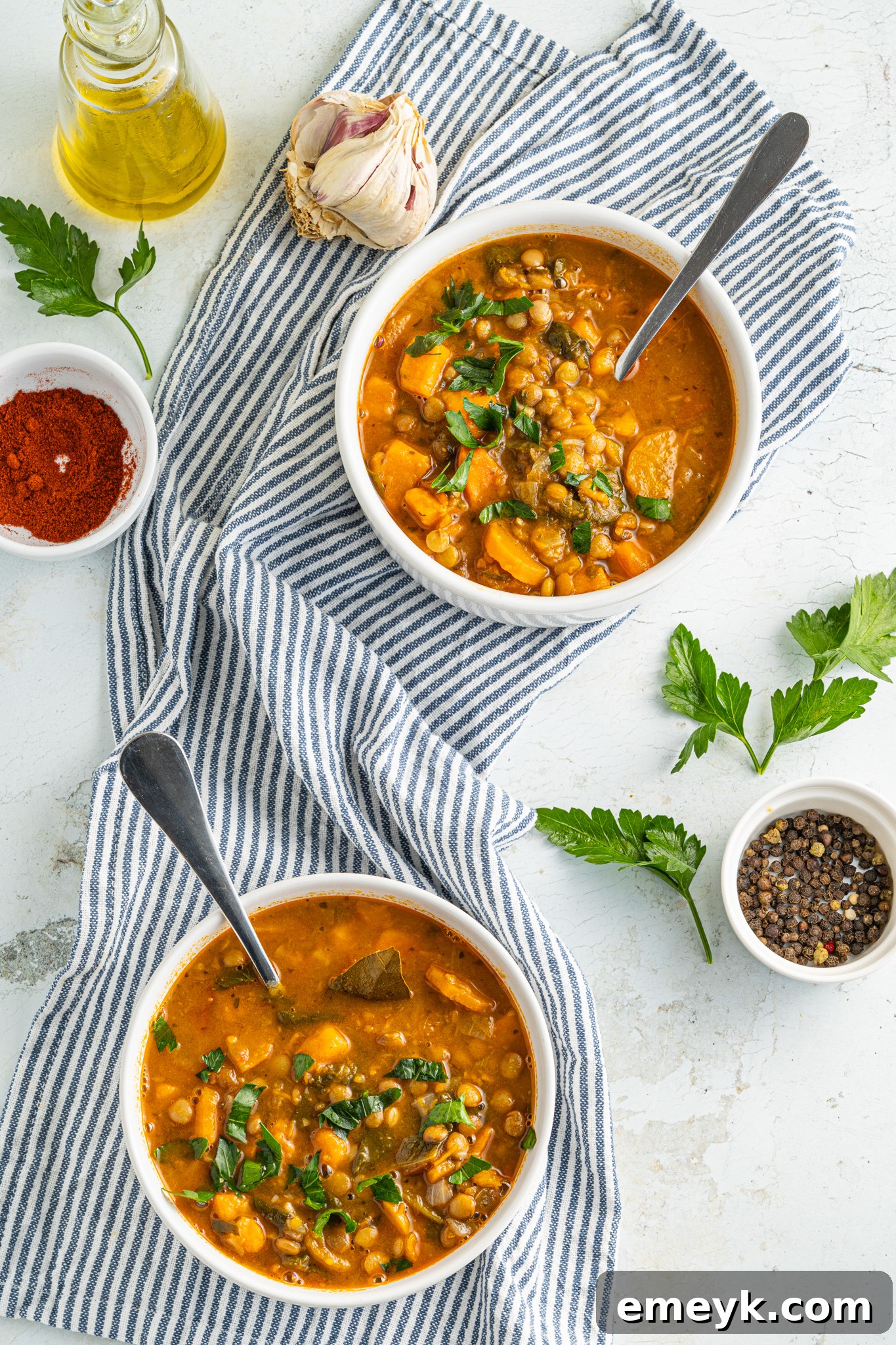 Two bowls of Sweet Potato Lentil Soup with spoons, ready to be enjoyed as a hearty meal.