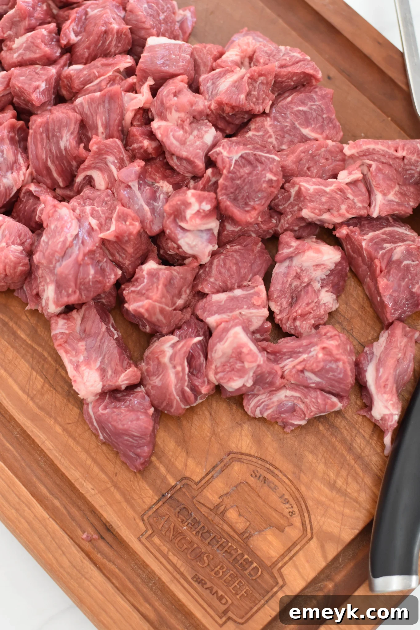Diced beef chuck roast on a cutting board, ready for browning for Slow Cooker Beef Curry.