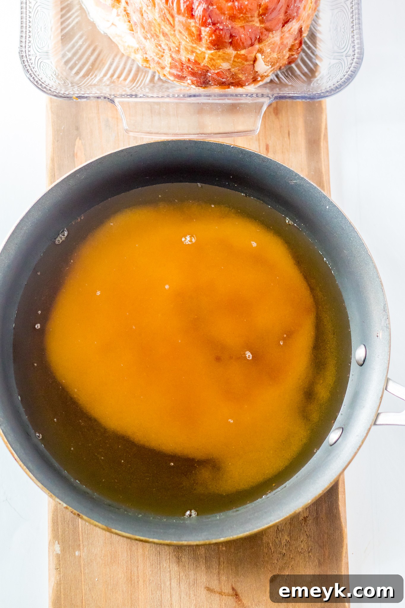 Apple Cider Glazed Ham Recipe sauce simmering in a pan.