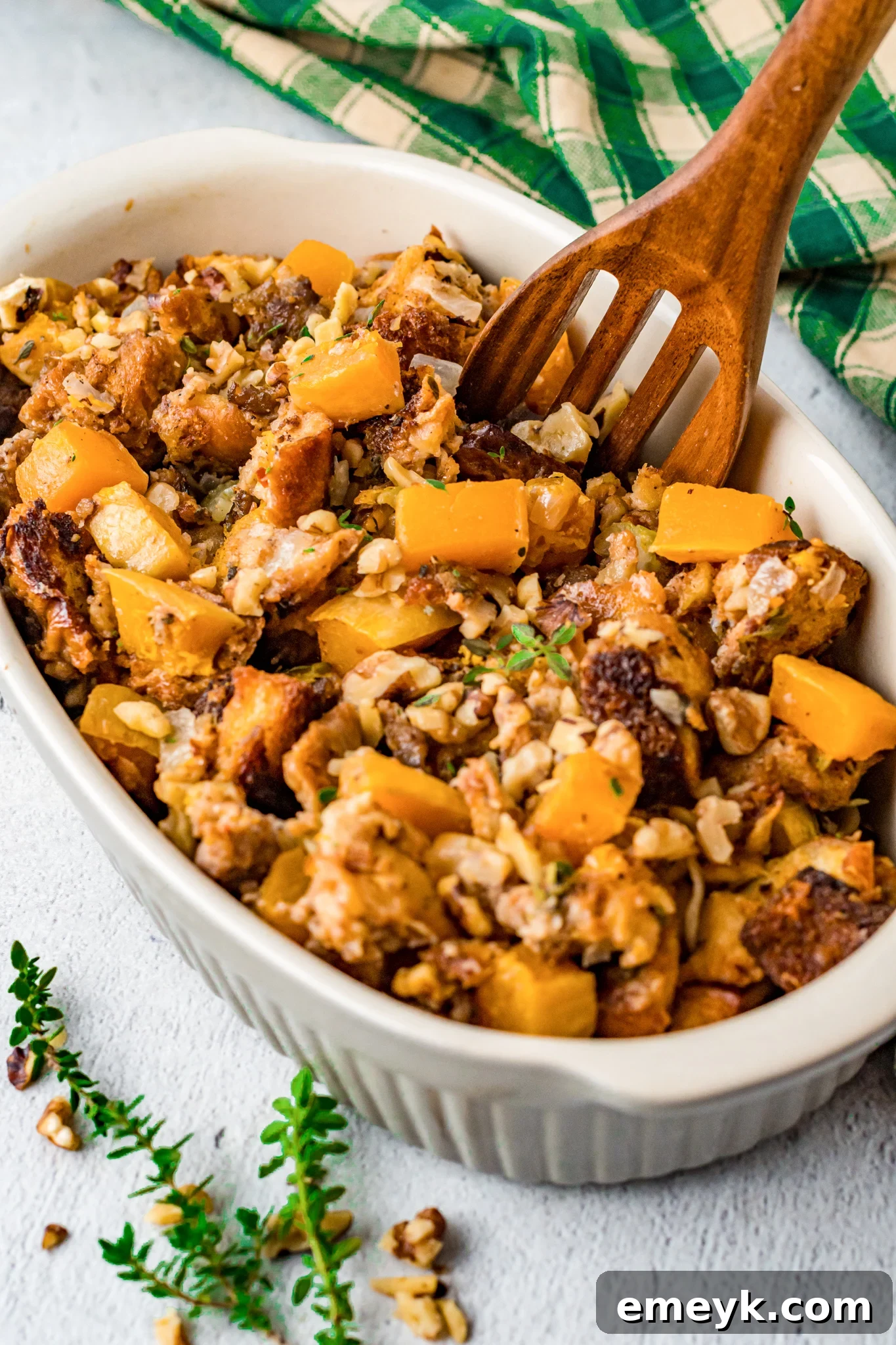 Harvest Butternut Squash Stuffing 2 Delicious Butternut Squash Stuffing in a white serving bowl, garnished with fresh herbs.