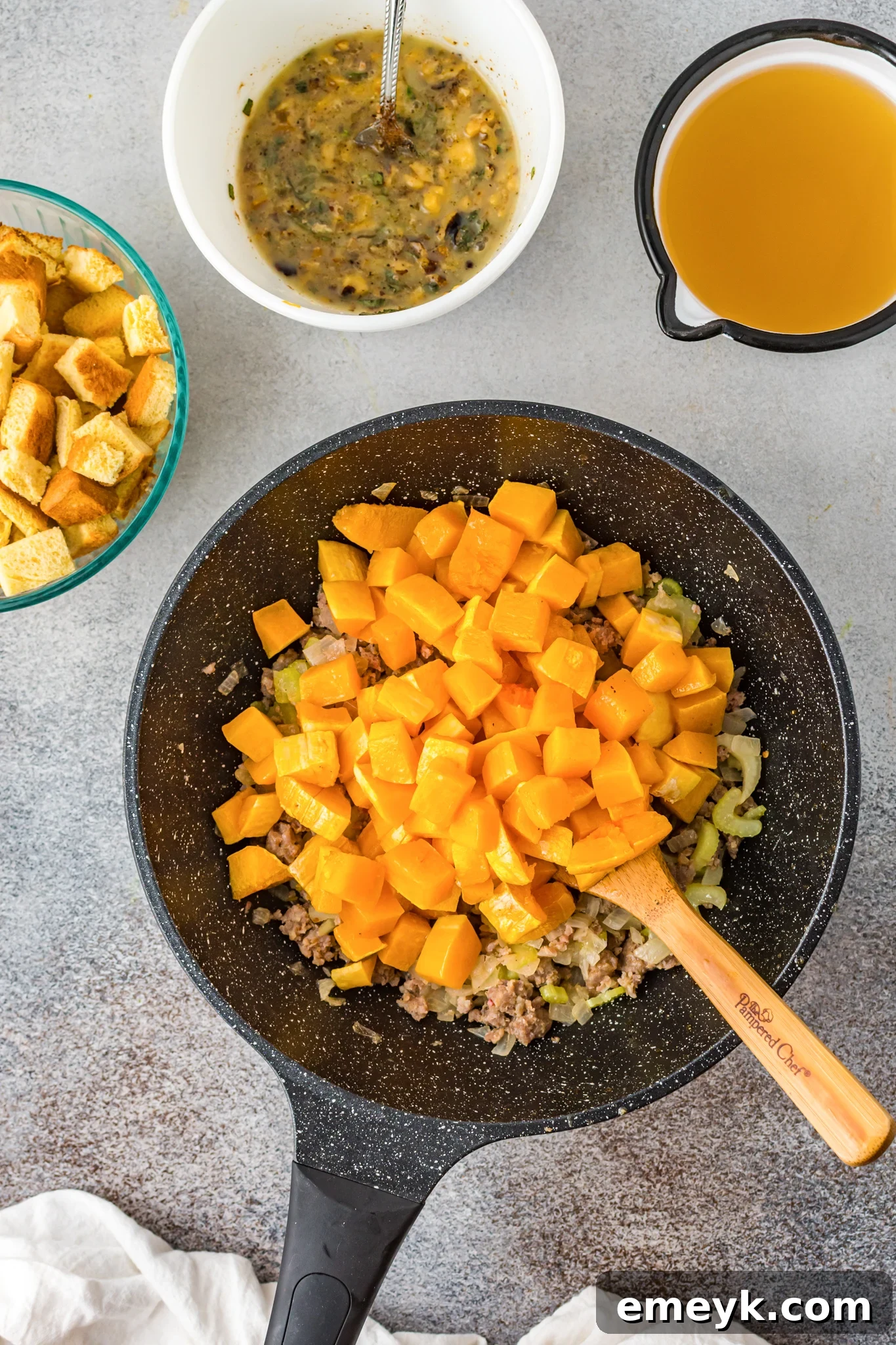 Harvest Butternut Squash Stuffing 8 Roasted butternut squash combined with sautéed sausage and vegetables in a large mixing bowl.