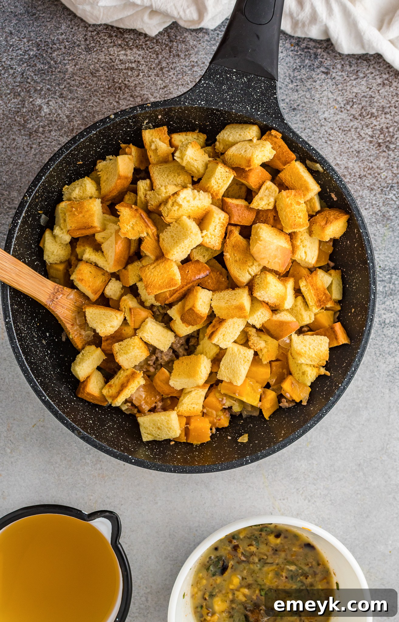 Harvest Butternut Squash Stuffing 9 Dried Italian bread cubes added to the stuffing mixture in a large bowl, ready for broth.