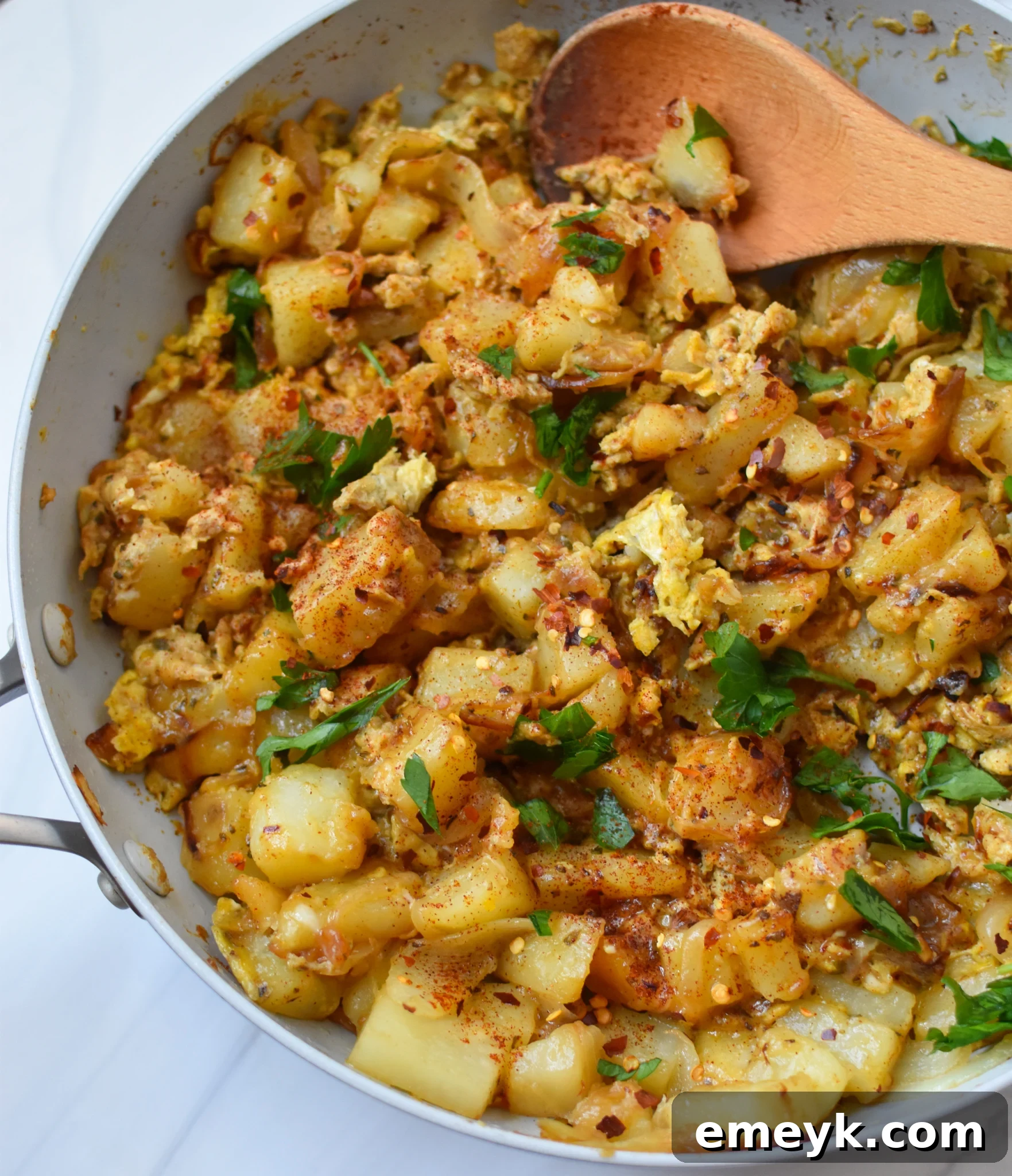 Lebanese Potato and Egg Recipe in a pan, garnished with fresh herbs, ready to be served.