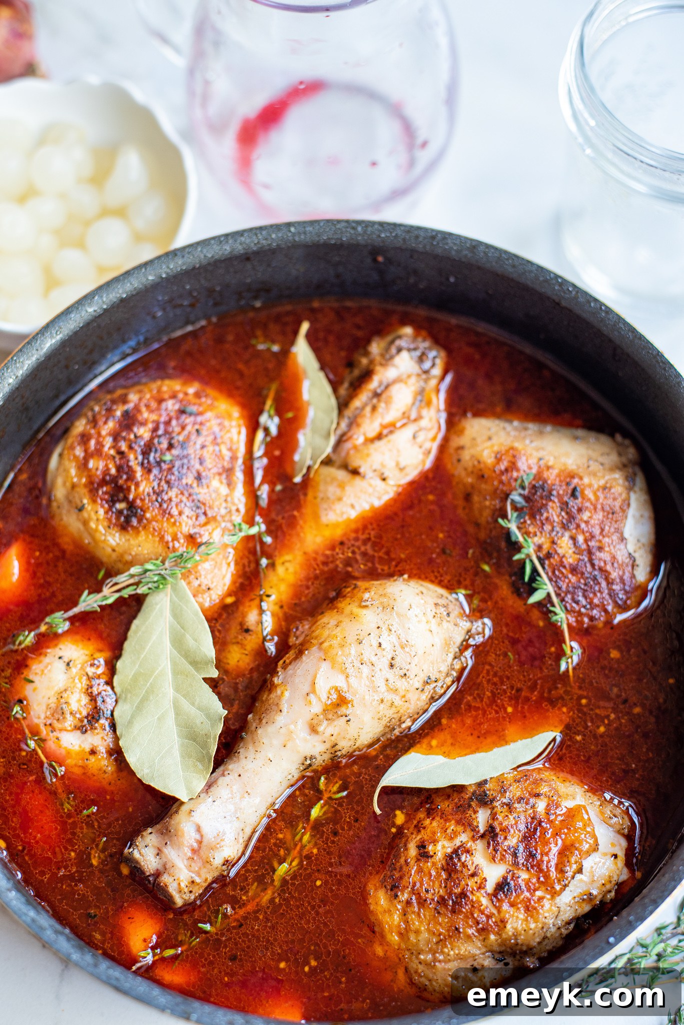 Coq au Vin Recipe: Tender chicken simmering in rich red wine sauce.