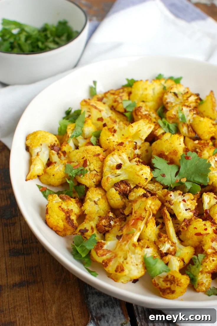 Vibrantly colored Turmeric Roasted Cauliflower florets, showcasing their bright yellow hue and slightly crispy edges, a healthful and flavorful side.