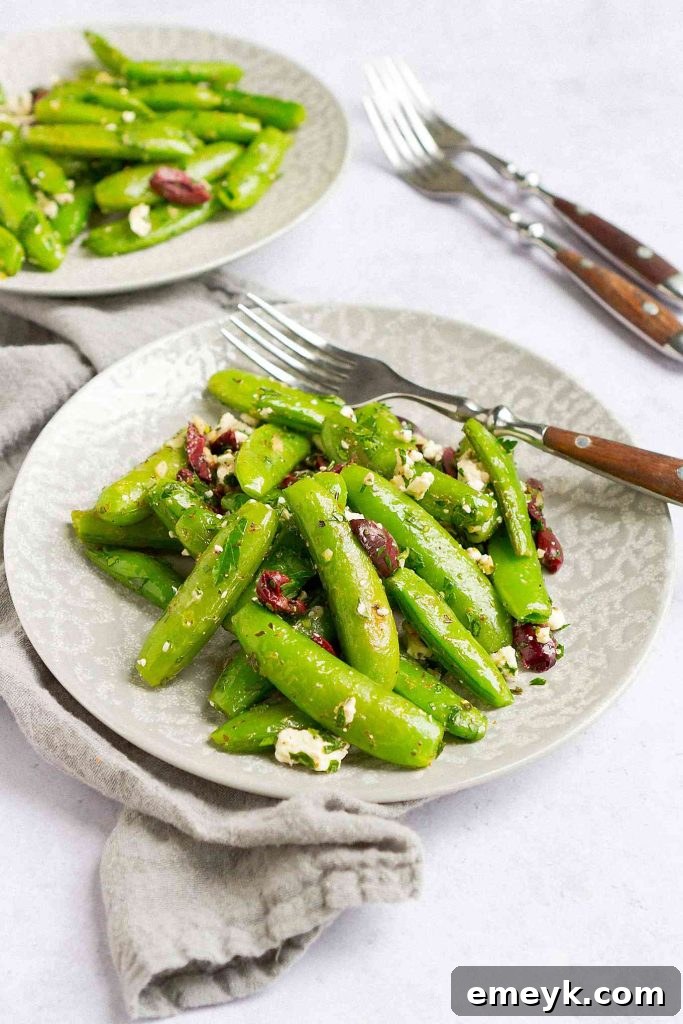 Bright green Greek Sugar Snap Peas Recipe, crisp-tender and seasoned with Mediterranean herbs, feta, and olives for a burst of flavor.