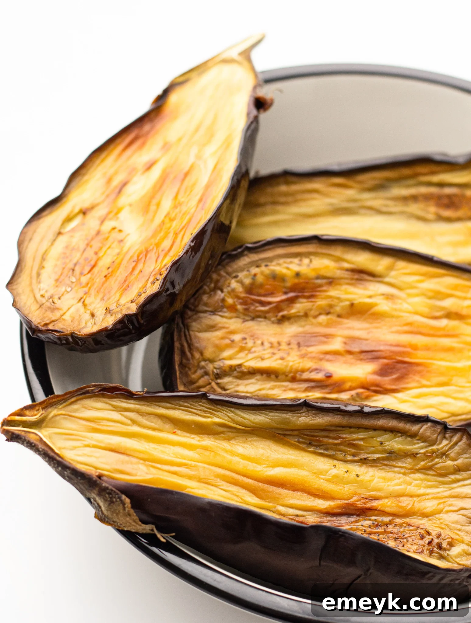 Crispy Air Fryer Eggplant cooking in an air fryer basket, showing golden-brown edges.