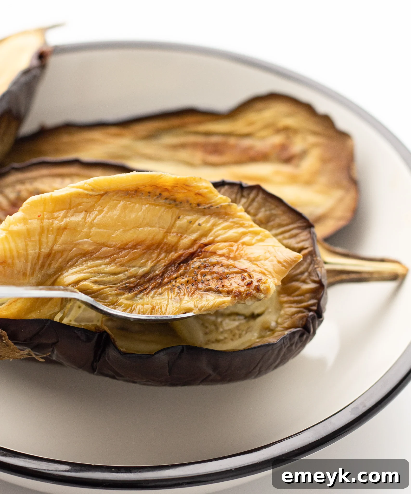 Cooked Air Fryer Eggplant, showing the soft, tender flesh being scooped out of the skin.