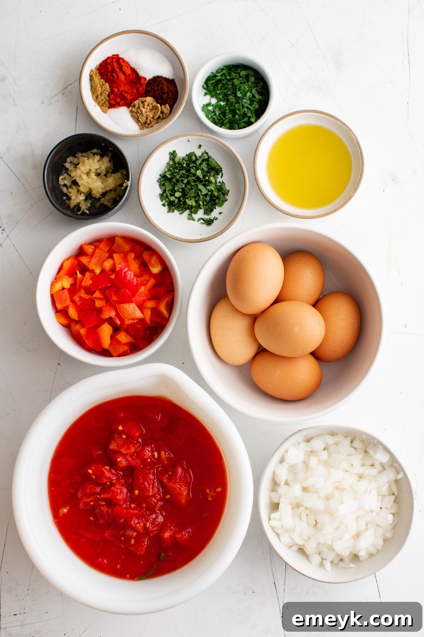 Array of fresh ingredients for Easy Shakshuka, including bell peppers, tomatoes, and spices.