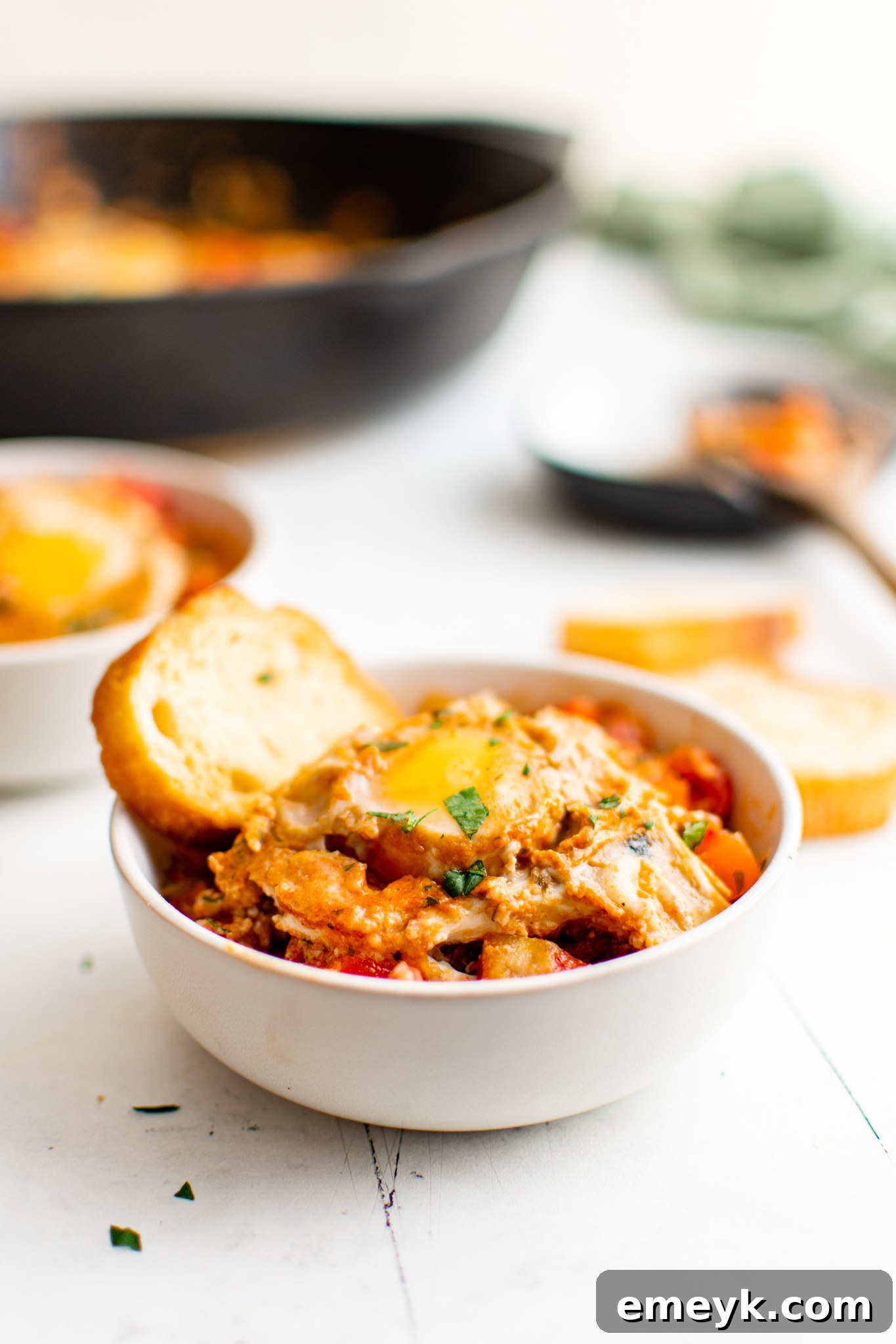 Easy Shakshuka served in a skillet with a side of bread.