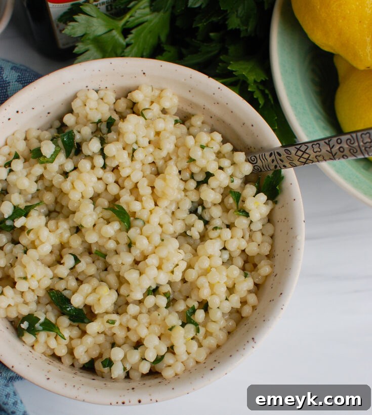 Fluffy Lemon Herb Couscous garnished with fresh parsley and lemon slices, a light and aromatic side dish.