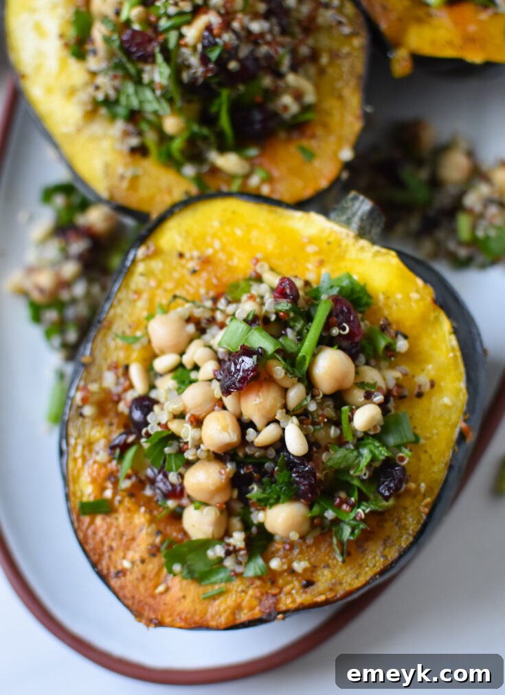 Elegant Mediterranean Stuffed Acorn Squash, halved and filled with a savory, herbaceous stuffing.