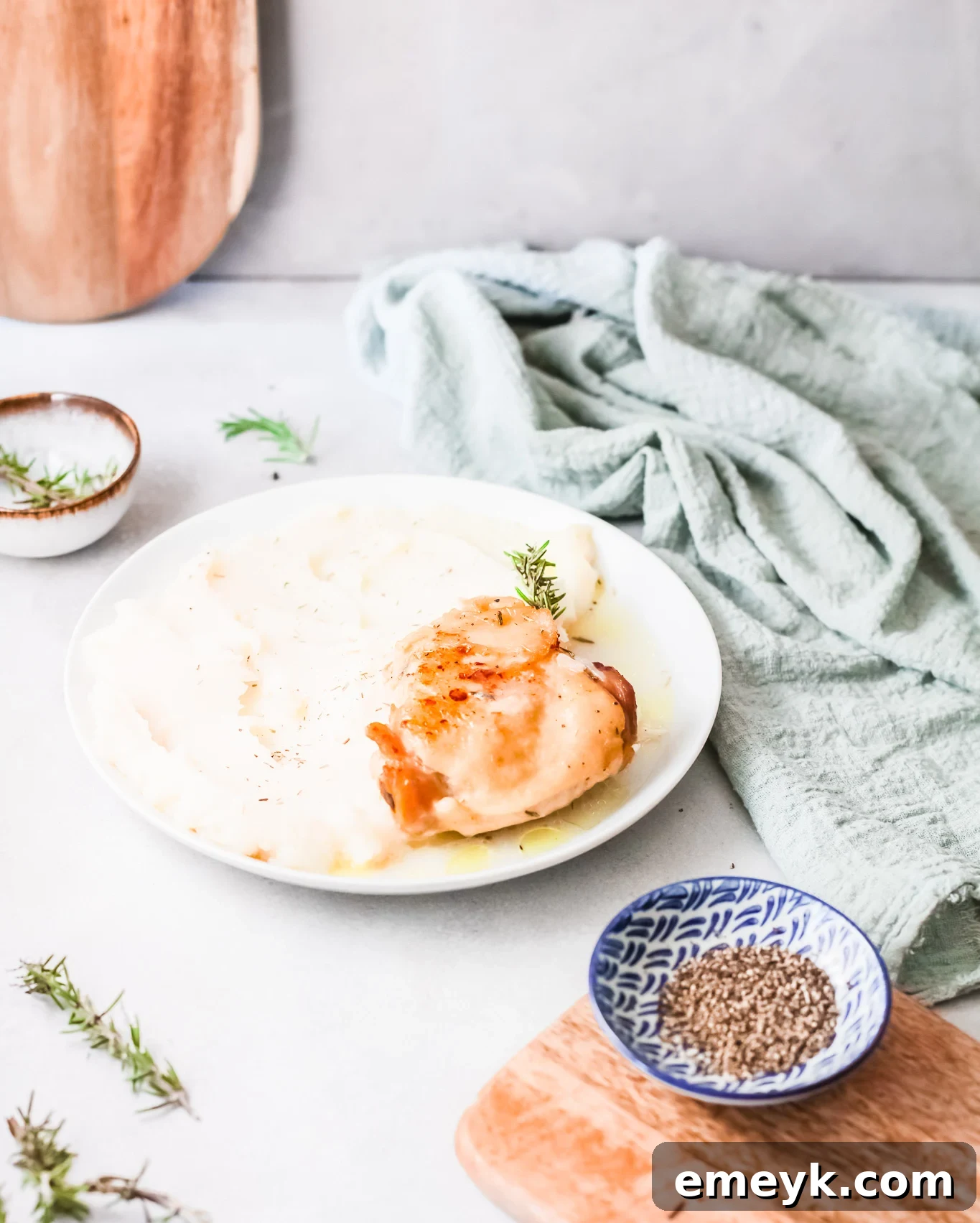 Instant Pot Creamy Rosemary Chicken on a plate with a blue napkin.
