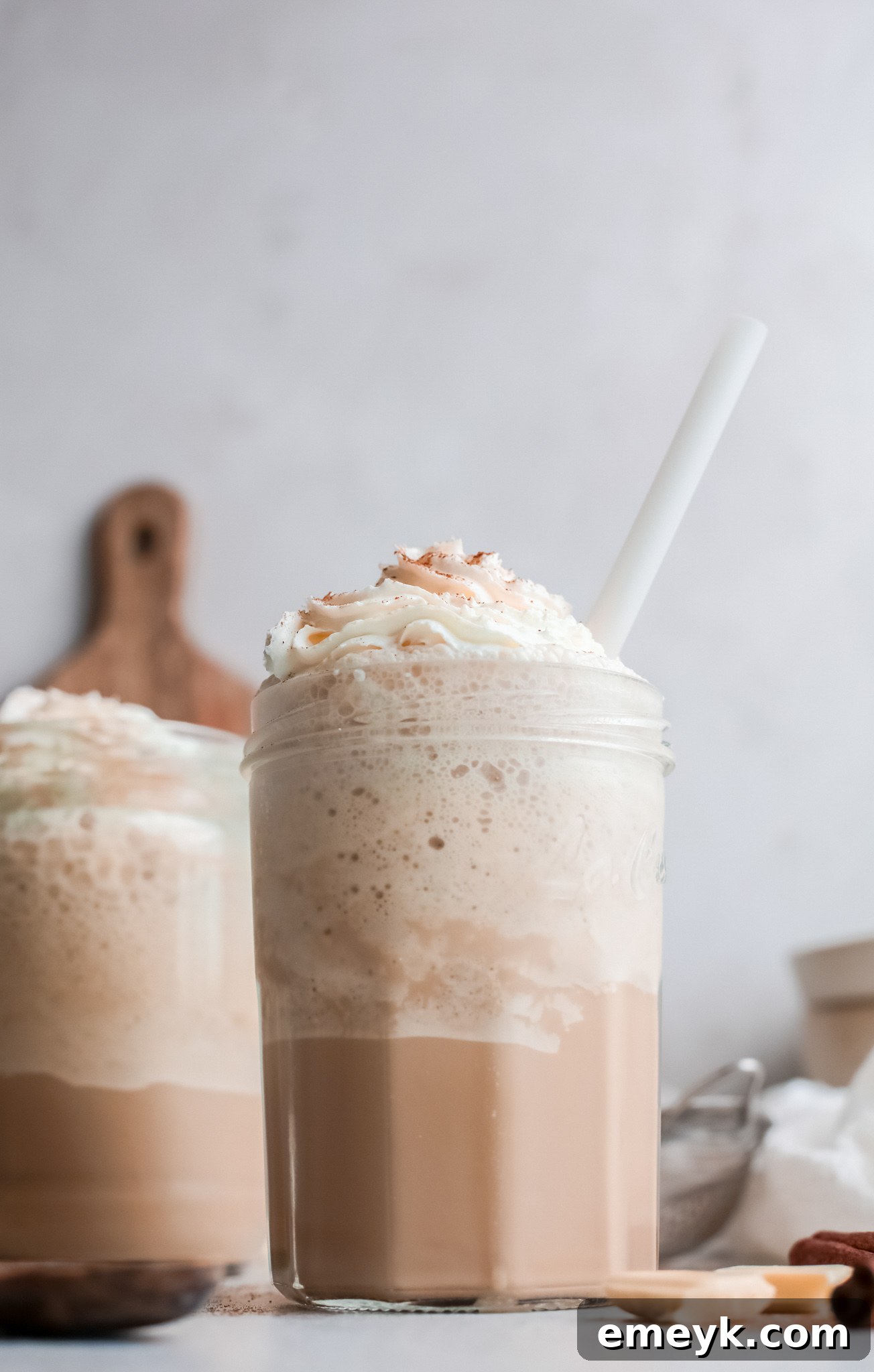A stunning White Chocolate Frappuccino in a clear glass cup, showcasing its pristine white color and perfectly smooth, frosty texture.