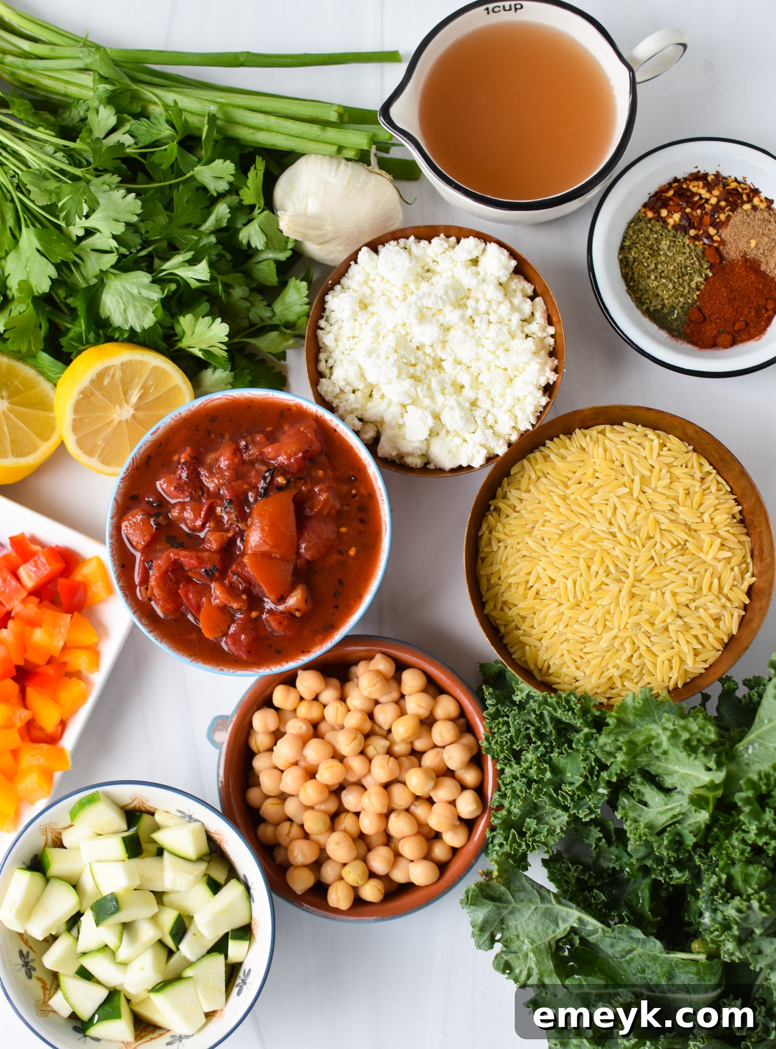Vibrant Mediterranean Orzo Pasta 3 A collection of fresh ingredients laid out for Mediterranean Orzo Pasta, including various spices, vegetables, and feta cheese.
