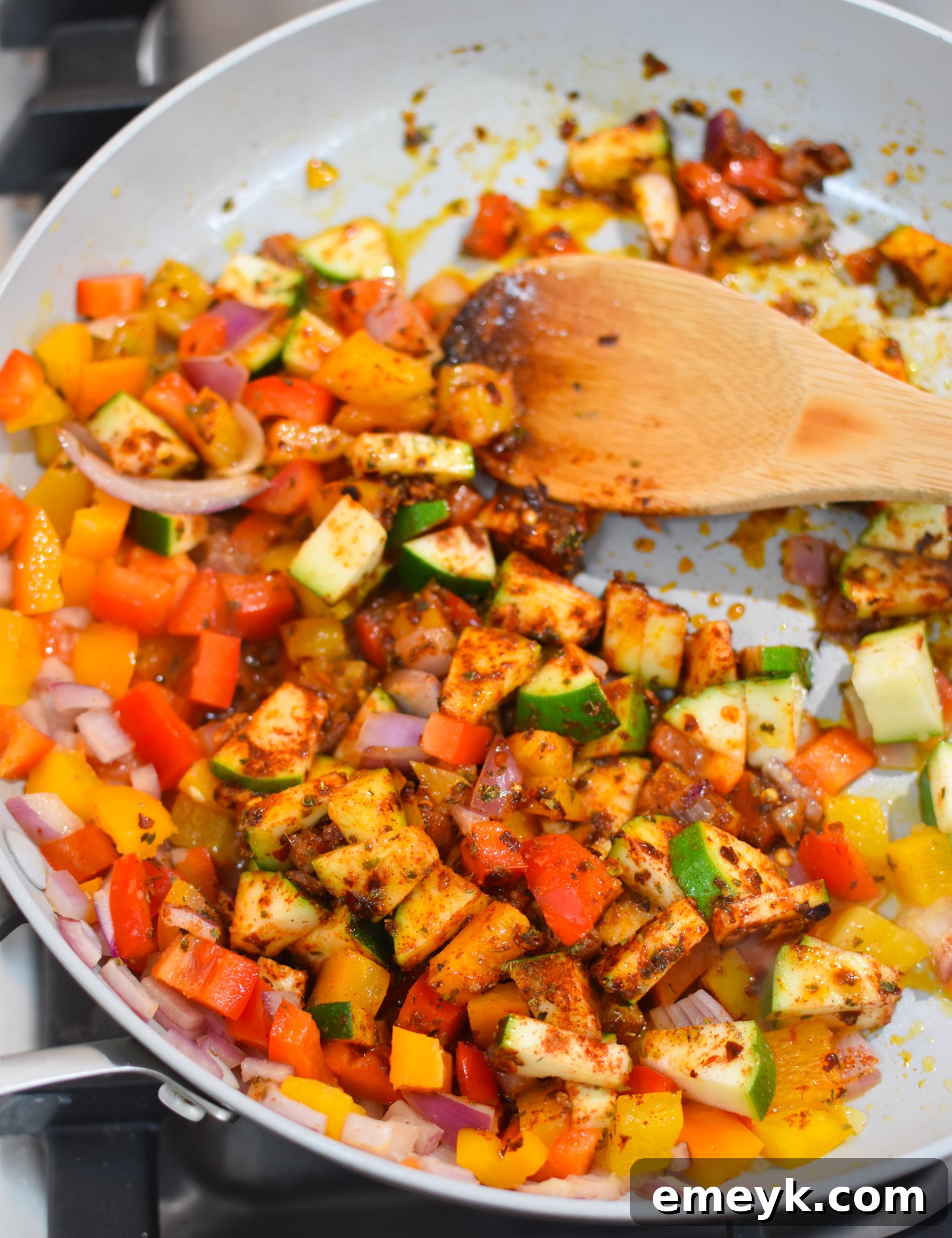 Vibrant Mediterranean Orzo Pasta 5 A large skillet showing Mediterranean Orzo Pasta ingredients being sautéed: onions, garlic, zucchini, and bell peppers.