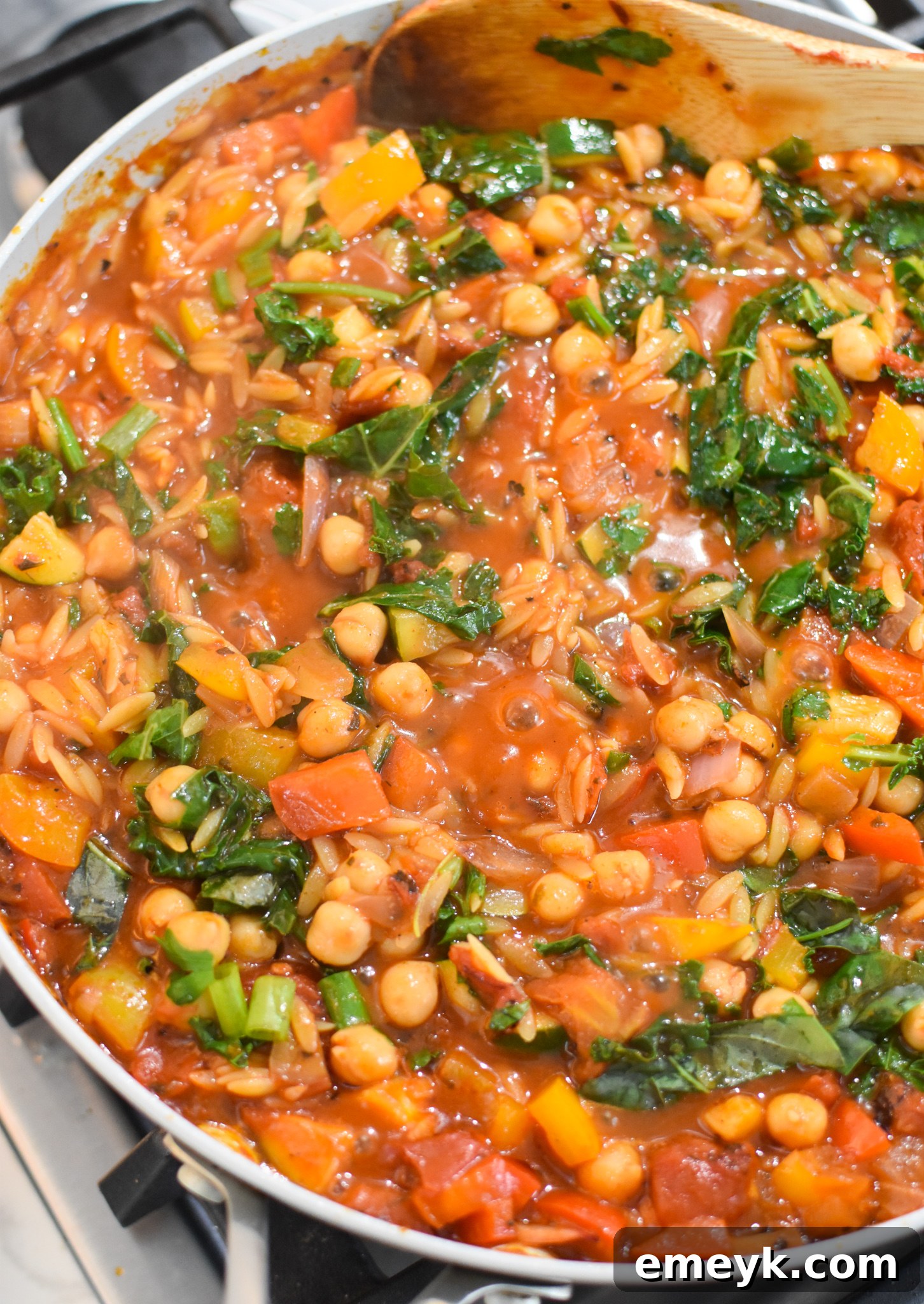 Vibrant Mediterranean Orzo Pasta 7 Close-up of Mediterranean Orzo Pasta with kale and chickpeas simmering in a skillet.