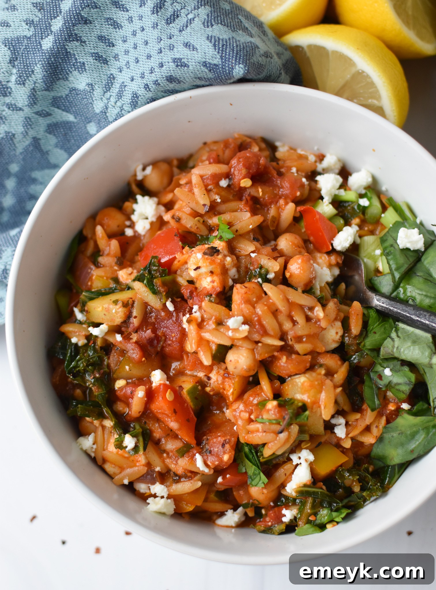 Vibrant Mediterranean Orzo Pasta 8 A bowl of Mediterranean Orzo Pasta, garnished with fresh herbs and feta, ready to be enjoyed with a spoon.