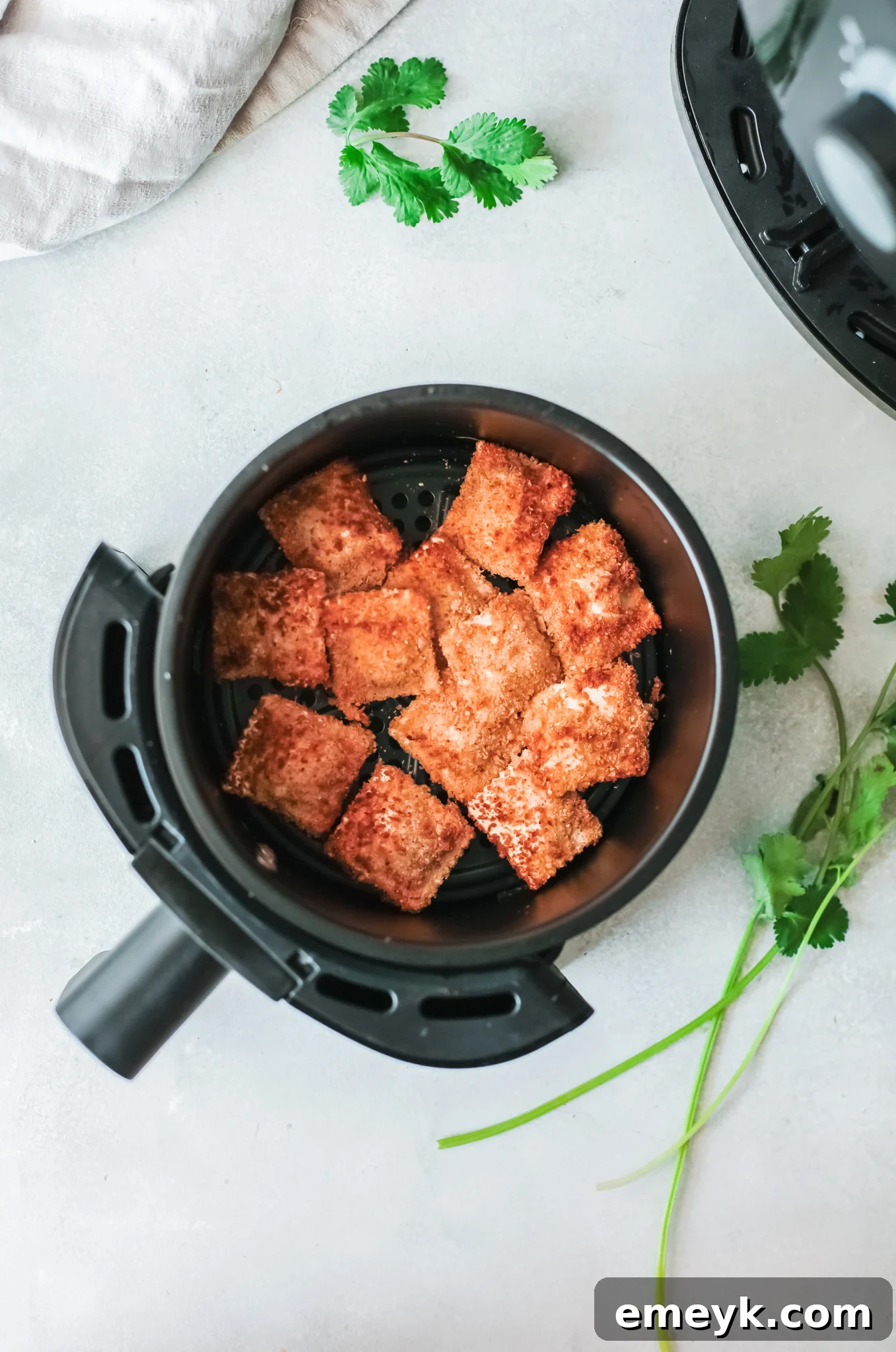 Crispy Air Fryer Ravioli 4 Air Fried Ravioli carefully placed in an air fryer basket, ready to cook.