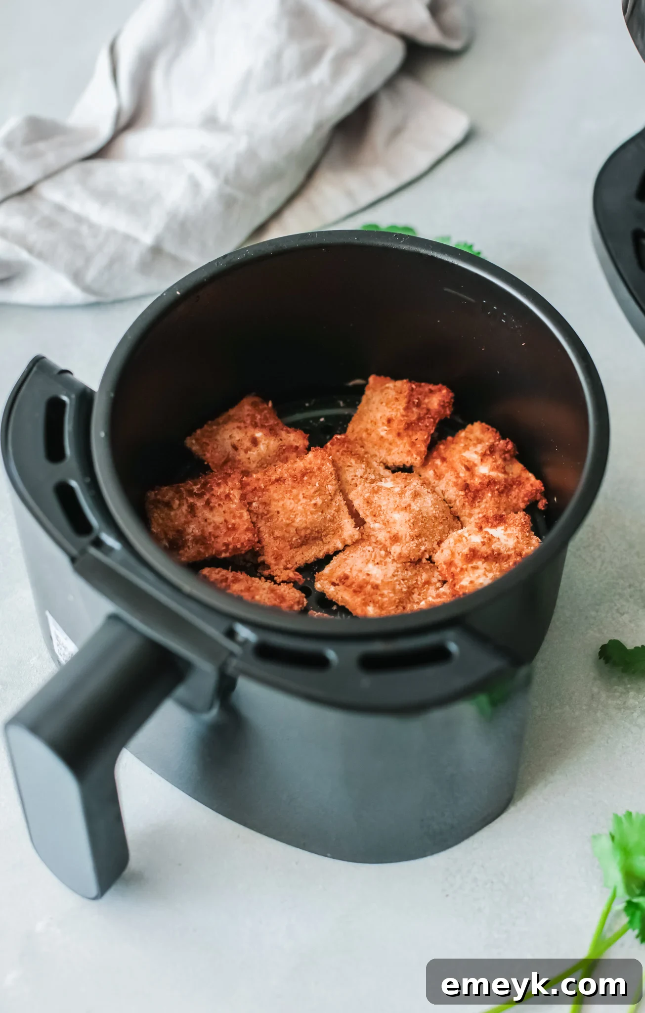 Crispy Air Fryer Ravioli 7 Crispy Air Fried Ravioli being removed from the air fryer basket.