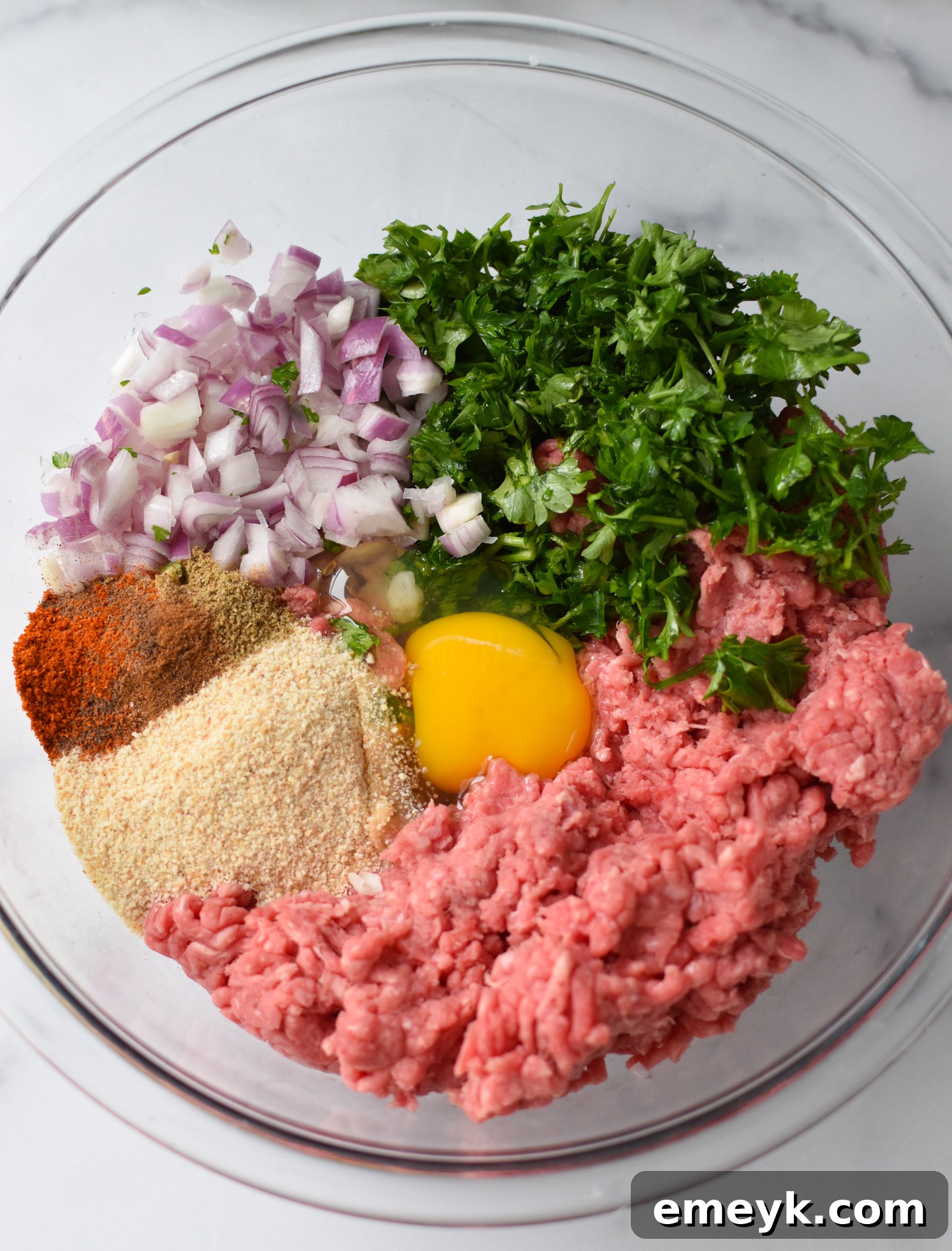A bowl of Mediterranean Baked Beef Meatballs ingredients, before mixing with ground beef.