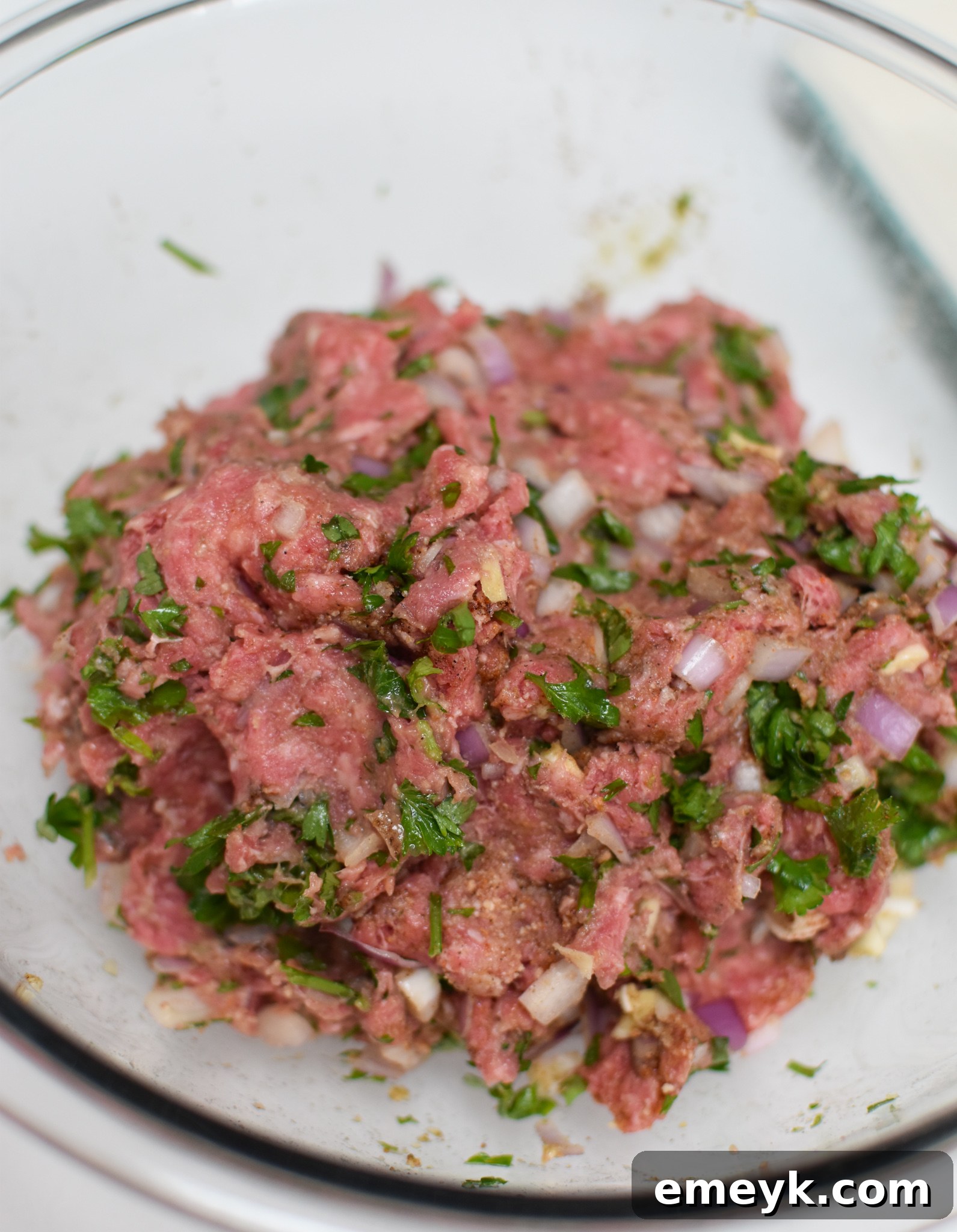 The ground beef mixture for Mediterranean Baked Beef Meatballs in a bowl, before forming.