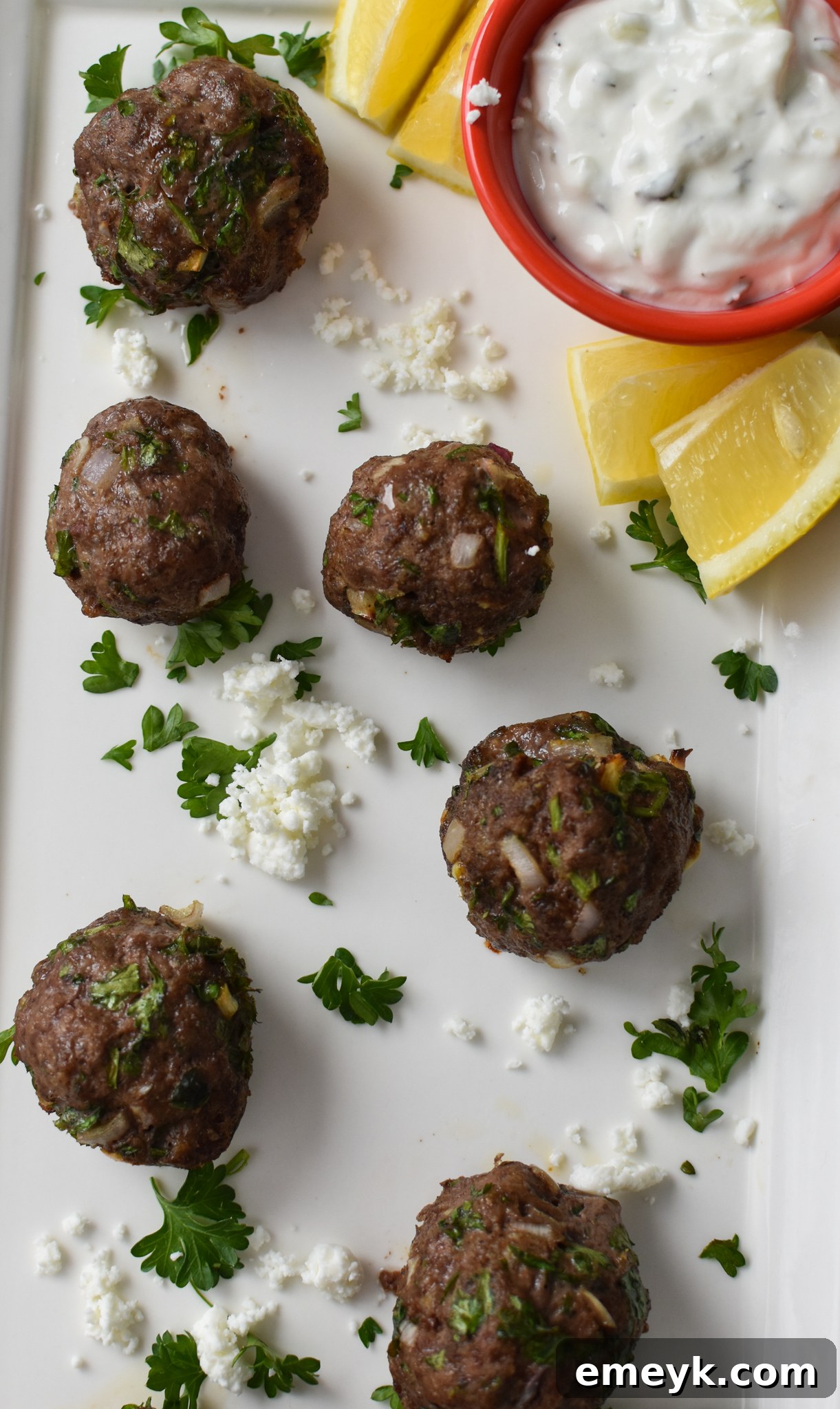 A platter of golden-brown Mediterranean Baked Beef Meatballs, ready to be enjoyed.