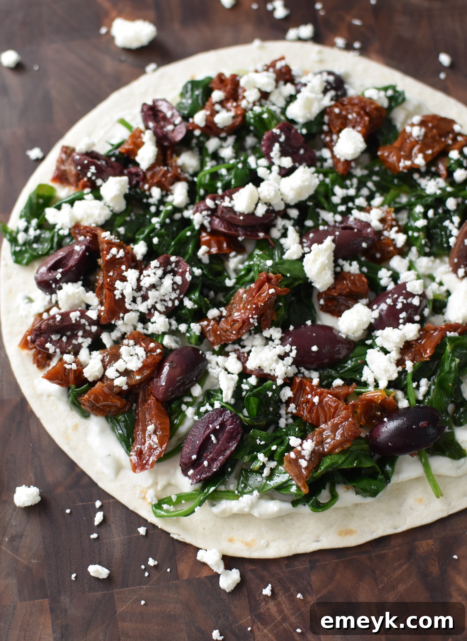 Simple Veggie Quesadillas 5 Mediterranean vegetarian quesadilla ingredients arranged on a tortilla before folding.
