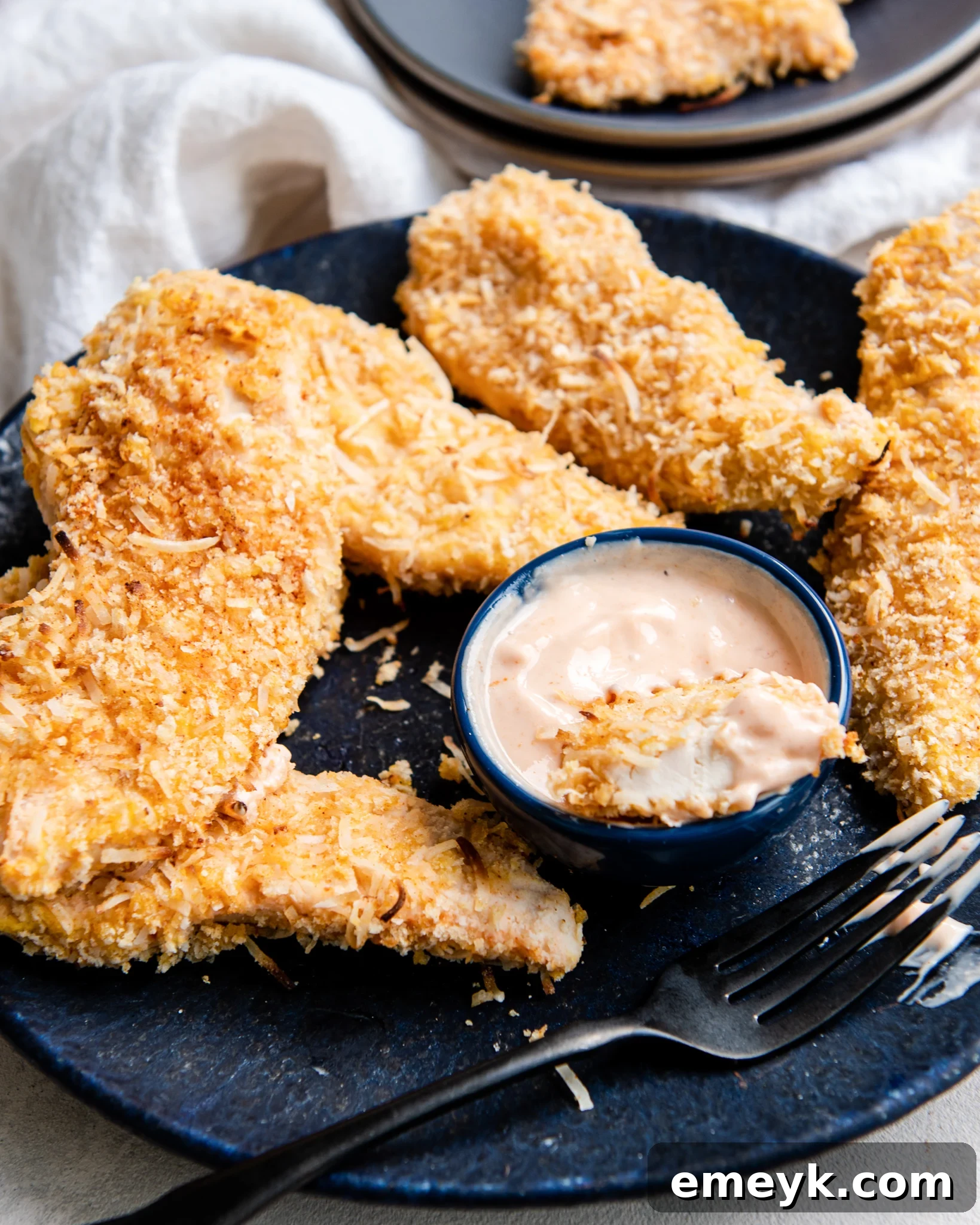 Crispy Air Fryer Coconut Chicken Tenders served with a side of dipping sauce.