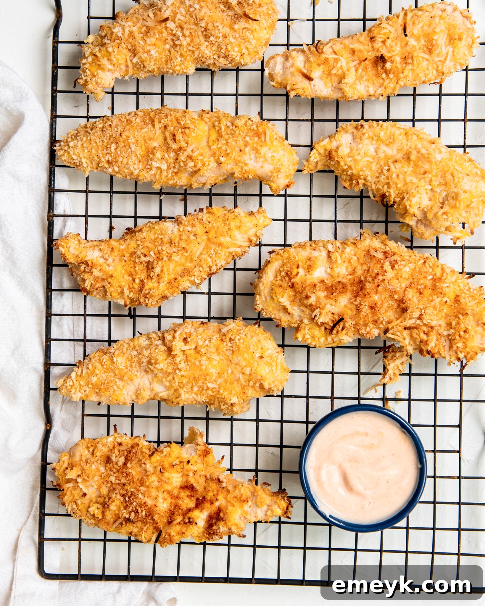 Air Fryer Coconut Chicken Tenders on a baking rack, ready to be cooked.