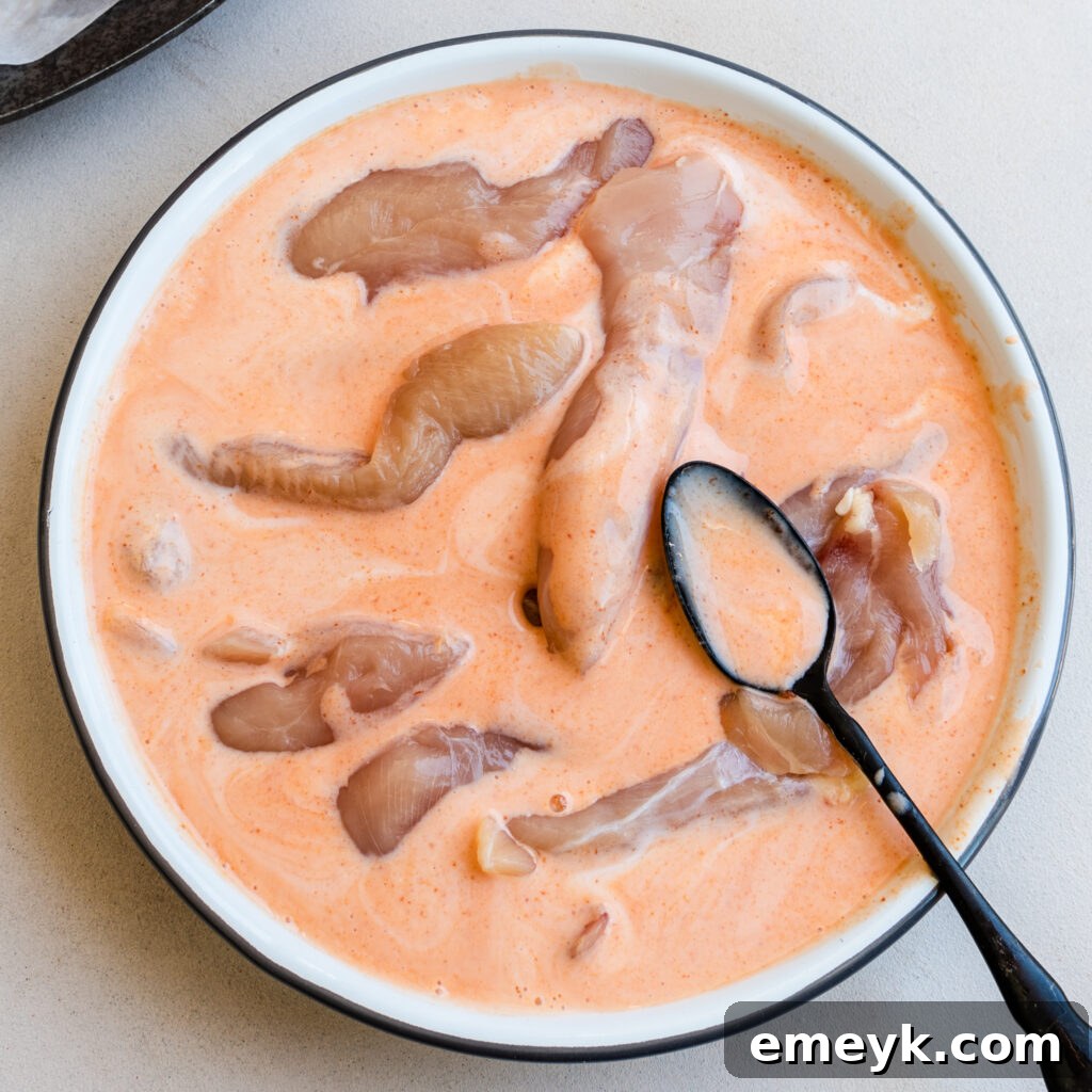 Chicken tenders marinating in buttermilk mixture.