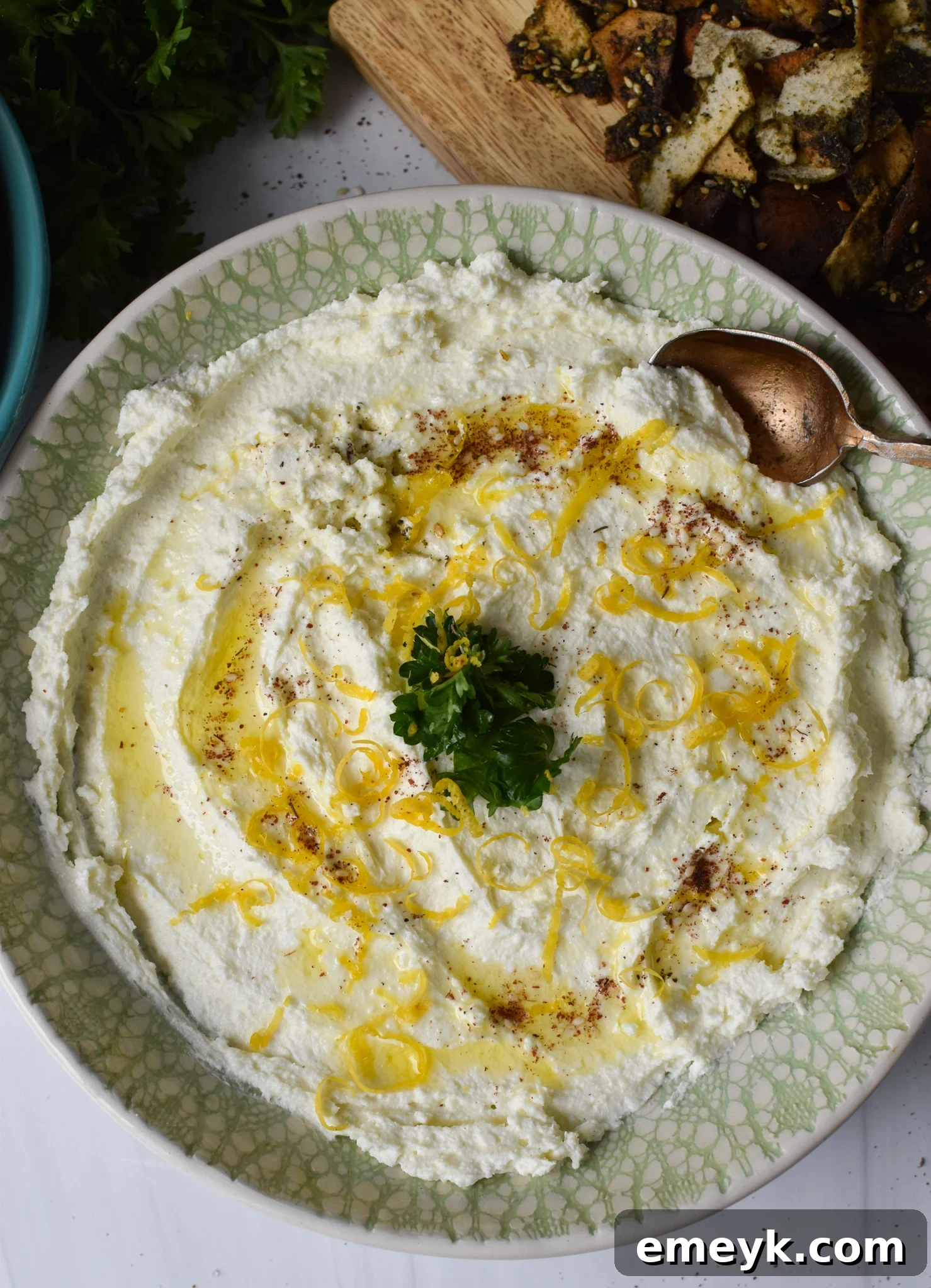 Lemon Whipped Feta Dip with a spoon, garnished with lemon zest and za'atar.