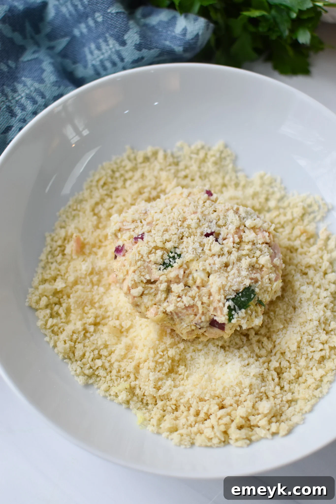 Sun Kissed Mediterranean Tuna Fritters 8 Mediterranean Tuna Patties being coated with breadcrumbs.