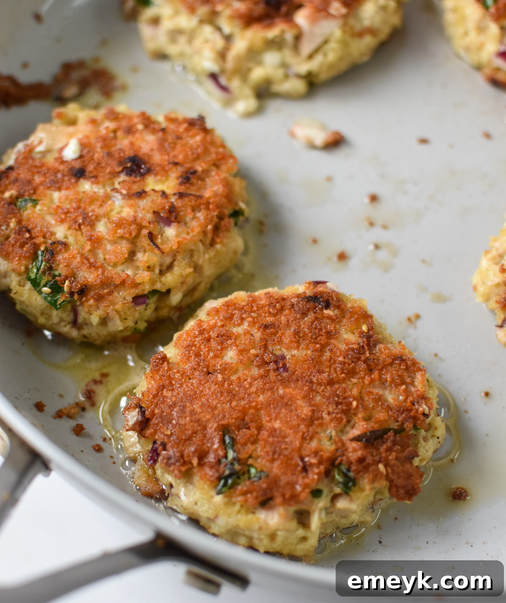 Sun Kissed Mediterranean Tuna Fritters 9 Mediterranean Tuna Patties cooking in a skillet.