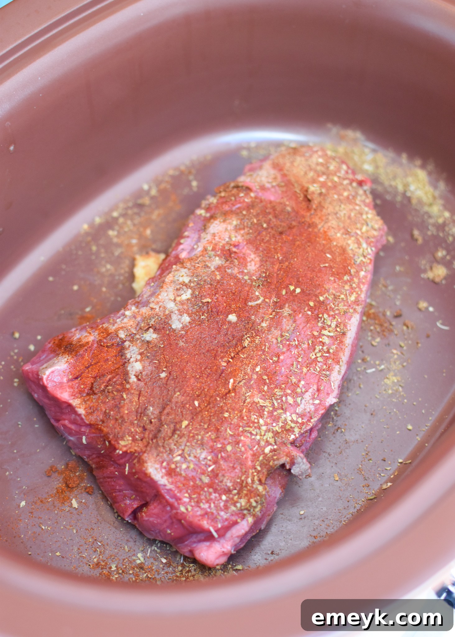 Chuck roast searing in a skillet before going into the slow cooker for hummus bowls.