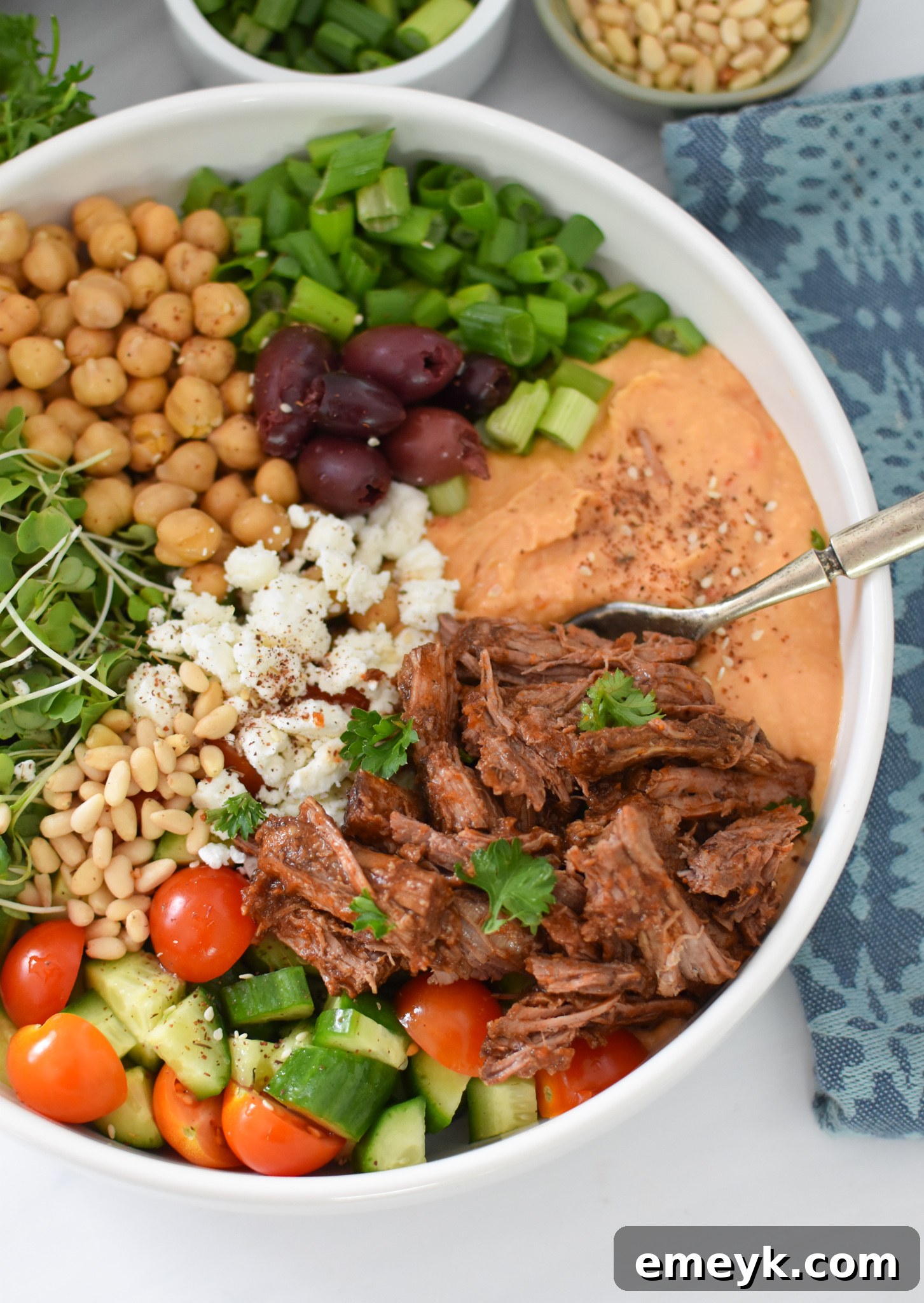 A finished Slow Cooker Shredded Beef Hummus Bowl with a fork, ready to eat.