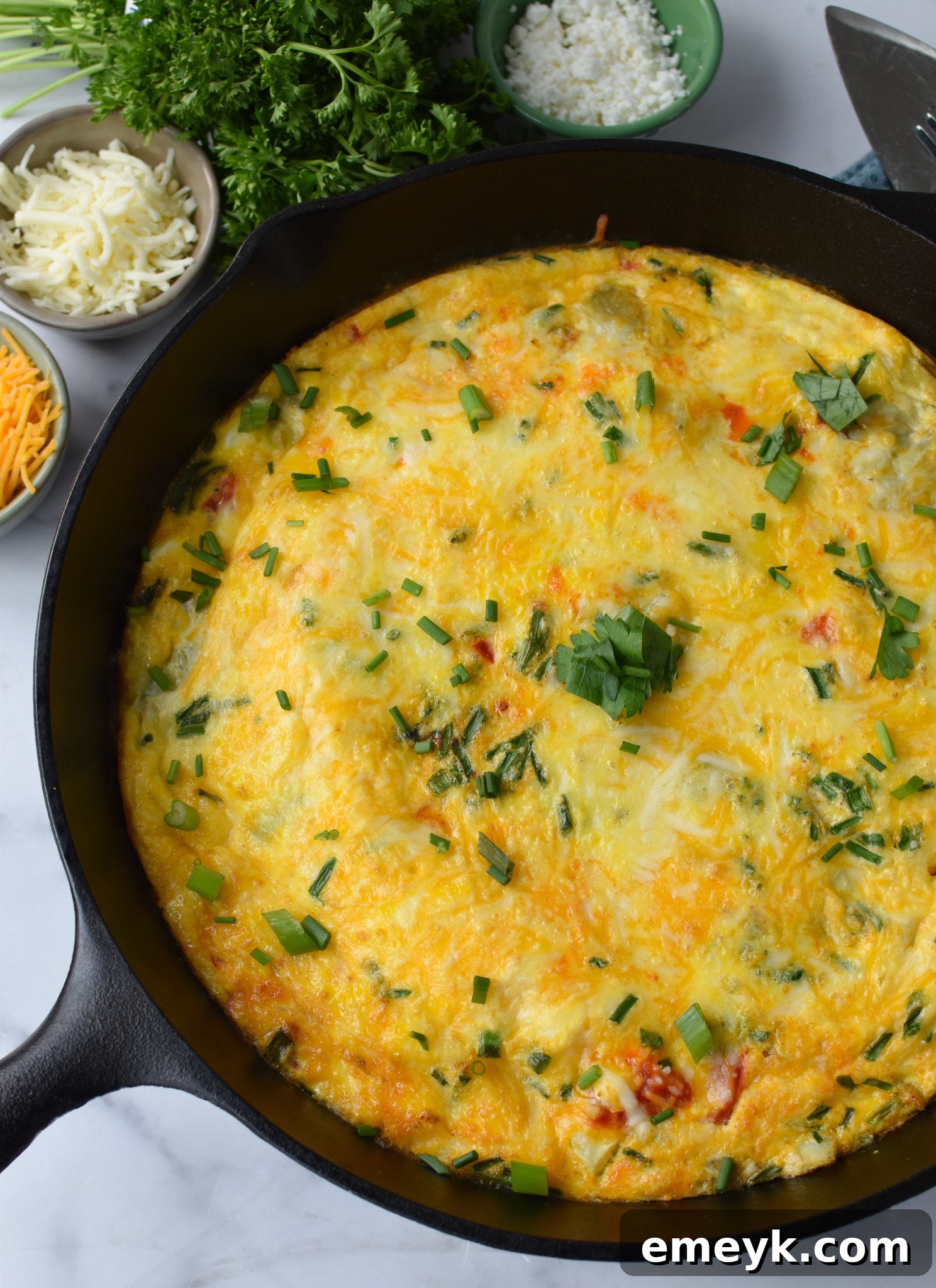 A vibrant Mediterranean Vegetable Frittata recipe, garnished with fresh chives, ready to be served.