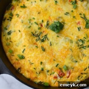 Close-up of a Mediterranean Vegetable Frittata slice with vibrant ingredients.
