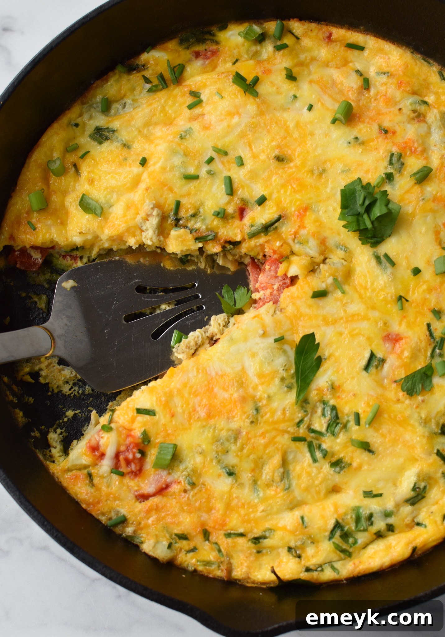 Mediterranean Vegetable Frittata Recipe being cut into slices with a pie server.