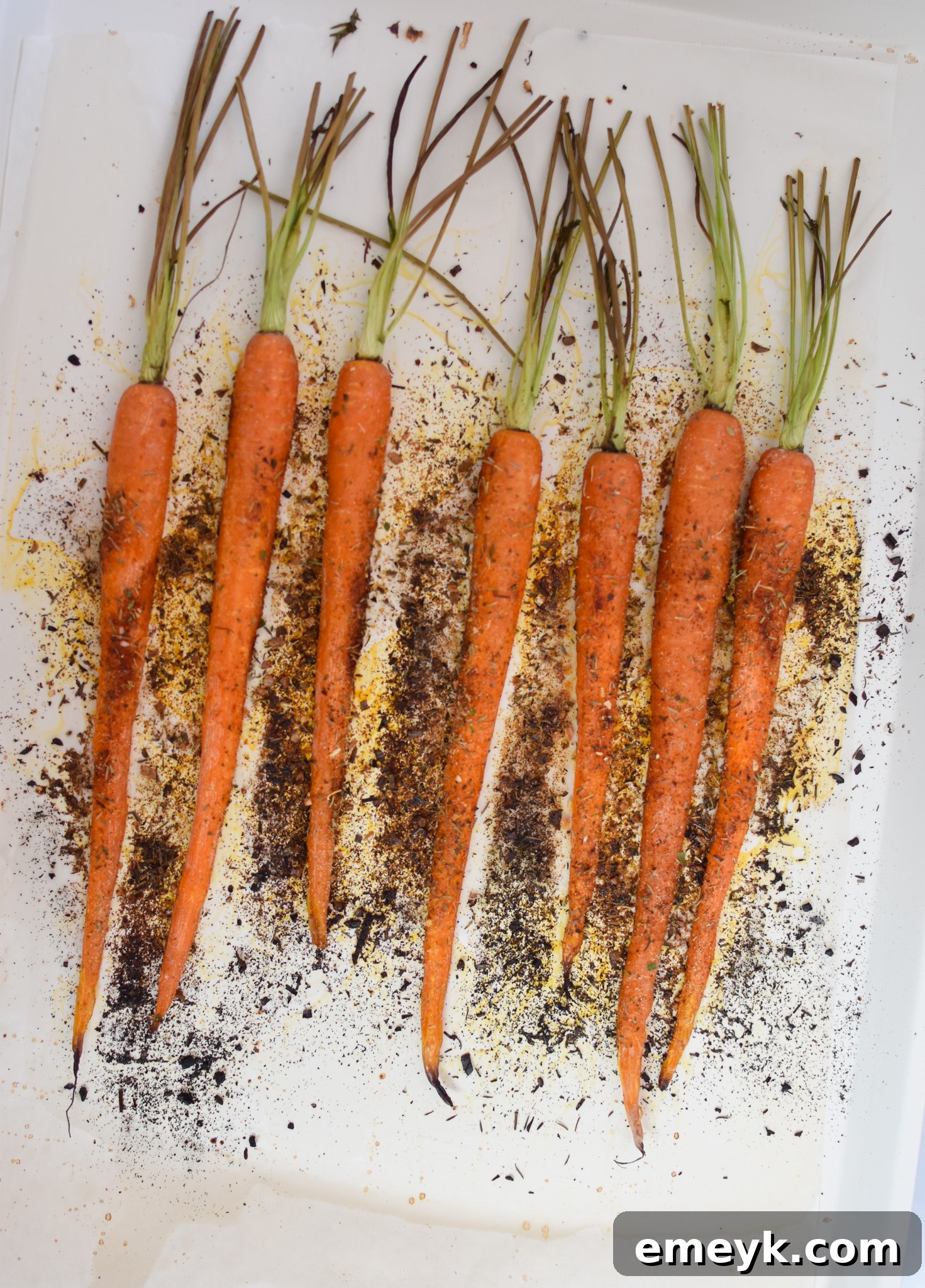 Closeup of perfectly roasted carrots, tender and slightly caramelized, on a baking sheet straight from the oven.