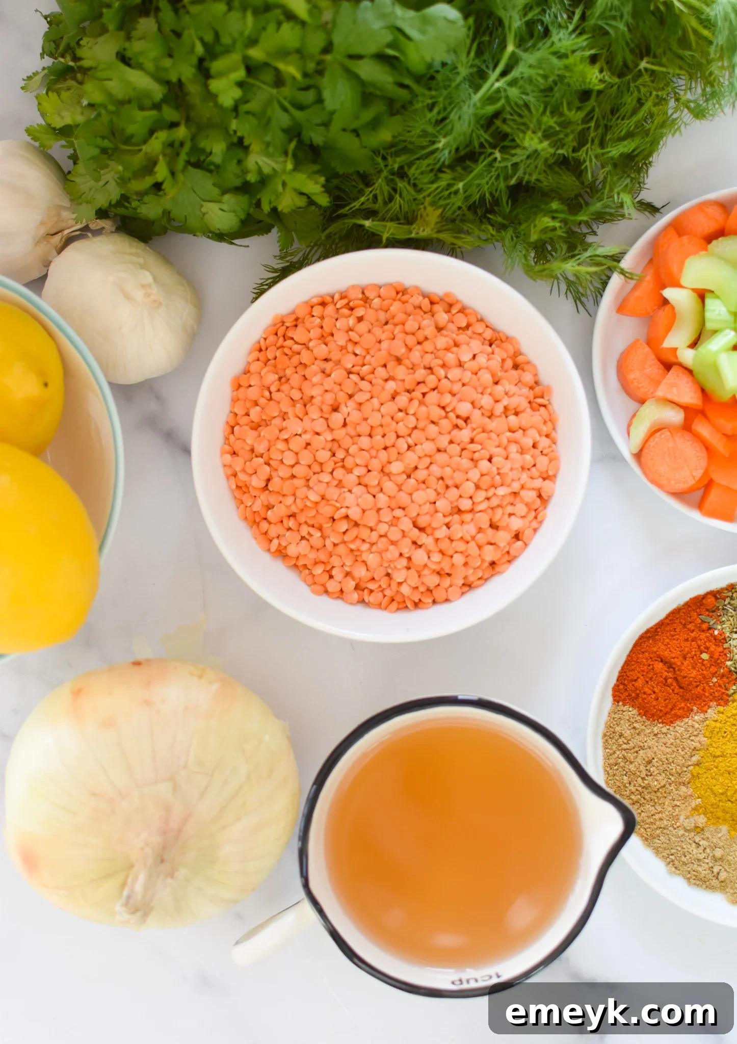 Fresh ingredients laid out for Lemon Lentil Soup recipe including lemons, lentils, and spices.