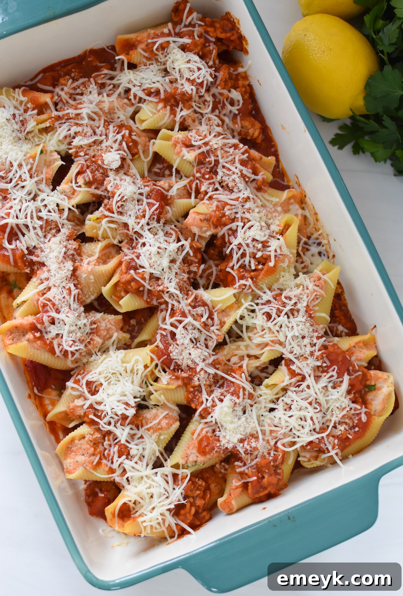 Close-up of Veal Stuffed Shells fresh out of the oven, topped with melted mozzarella and parmesan cheese.