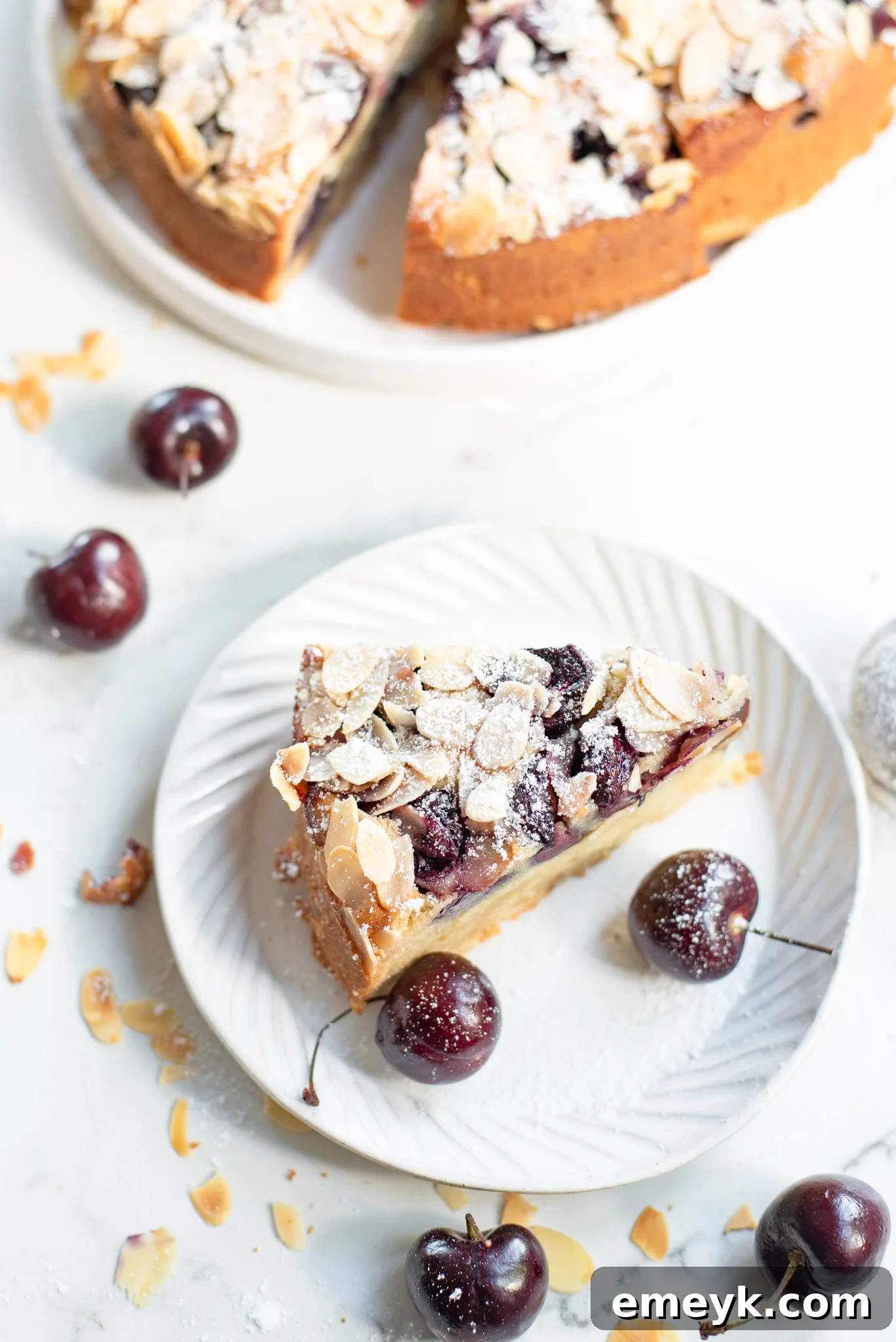 Decadent Cherry Almond Cake 3 Close-up of a single slice of Cherry Almond Cake on a white plate, highlighting the perfectly baked cherries and golden crust.