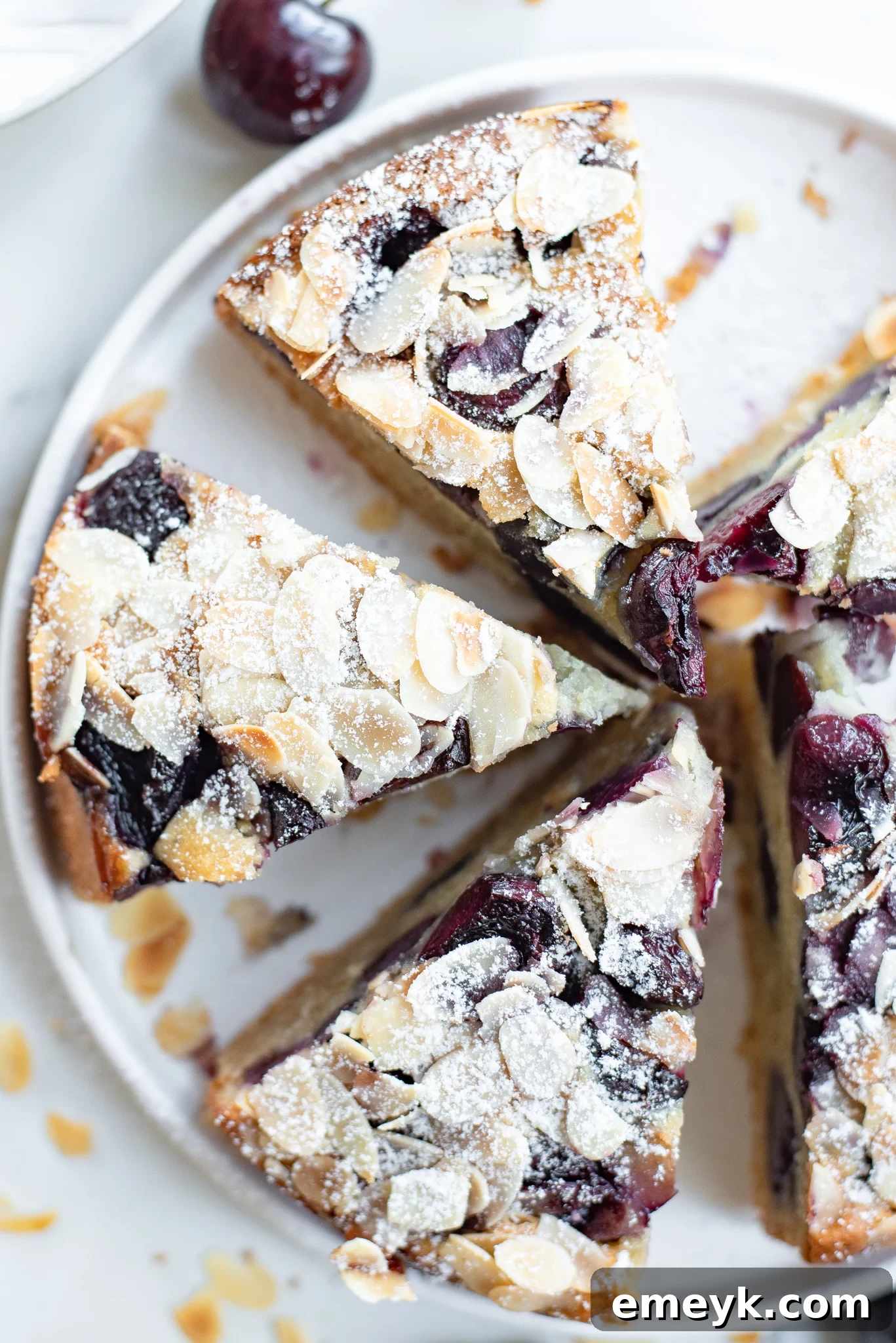 Decadent Cherry Almond Cake 4 A beautifully sliced piece of Cherry Almond Cake with a perfect crust and visible cherries and almonds.
