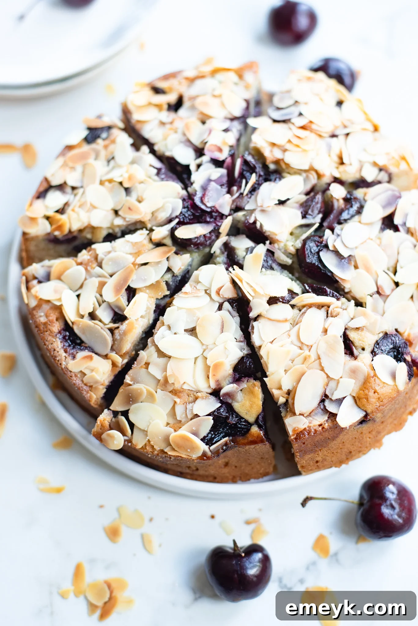 Decadent Cherry Almond Cake 5 A whole Cherry Almond Cake, beautifully garnished with fresh cherries and sliced almonds.