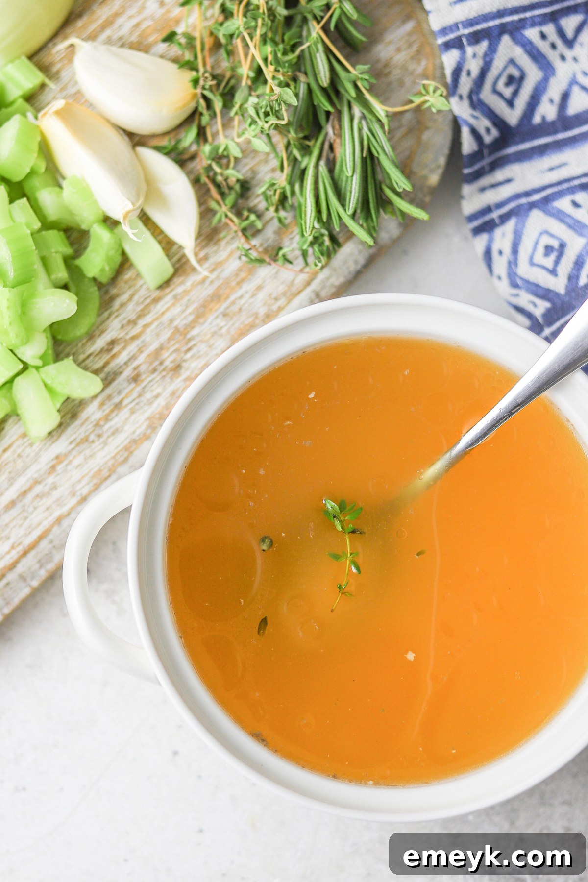 A bowl of homemade chicken broth with a spoon, ready to be enjoyed.