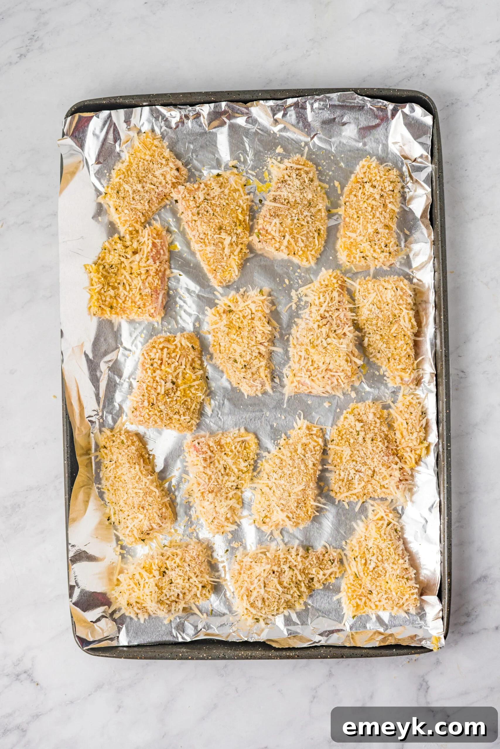 Tilapia fish strips being breaded for fish sticks.