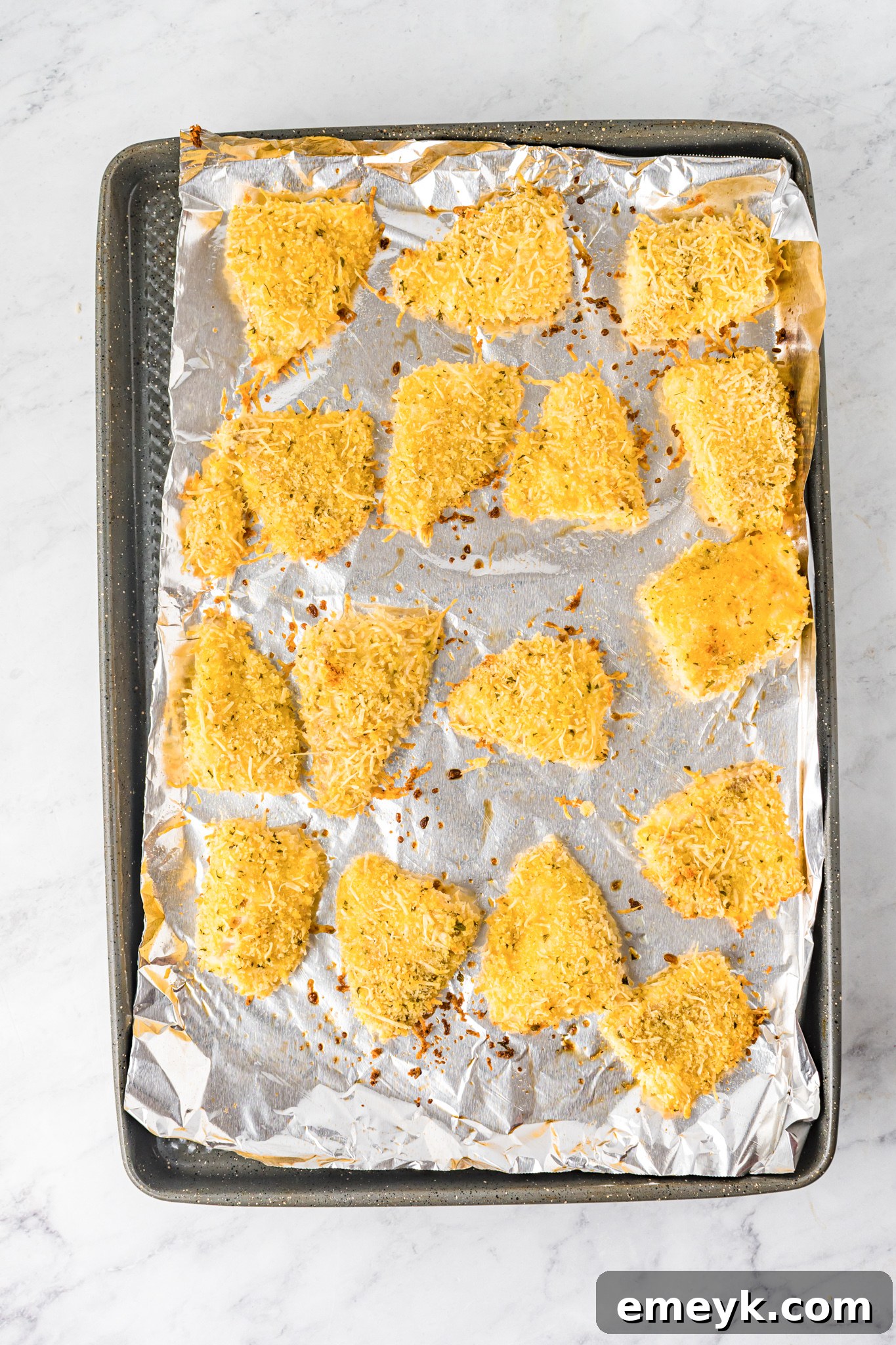 Baked Parmesan Fish Sticks arranged on a baking sheet.