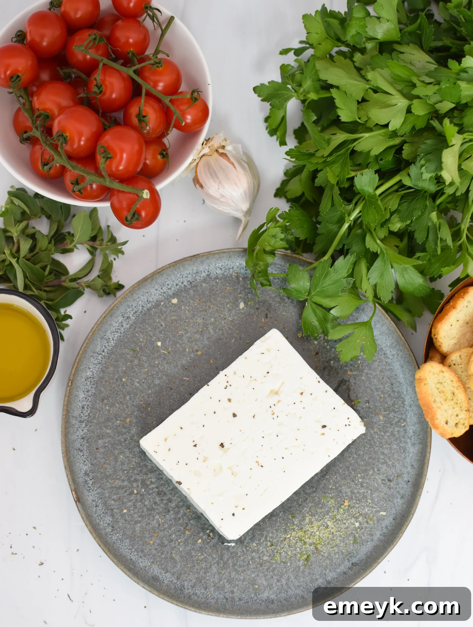 Effortless Baked Feta Delight 3 Close-up of fresh ingredients for Easy Baked Feta: block feta, cherry tomatoes, olive oil, and herbs.